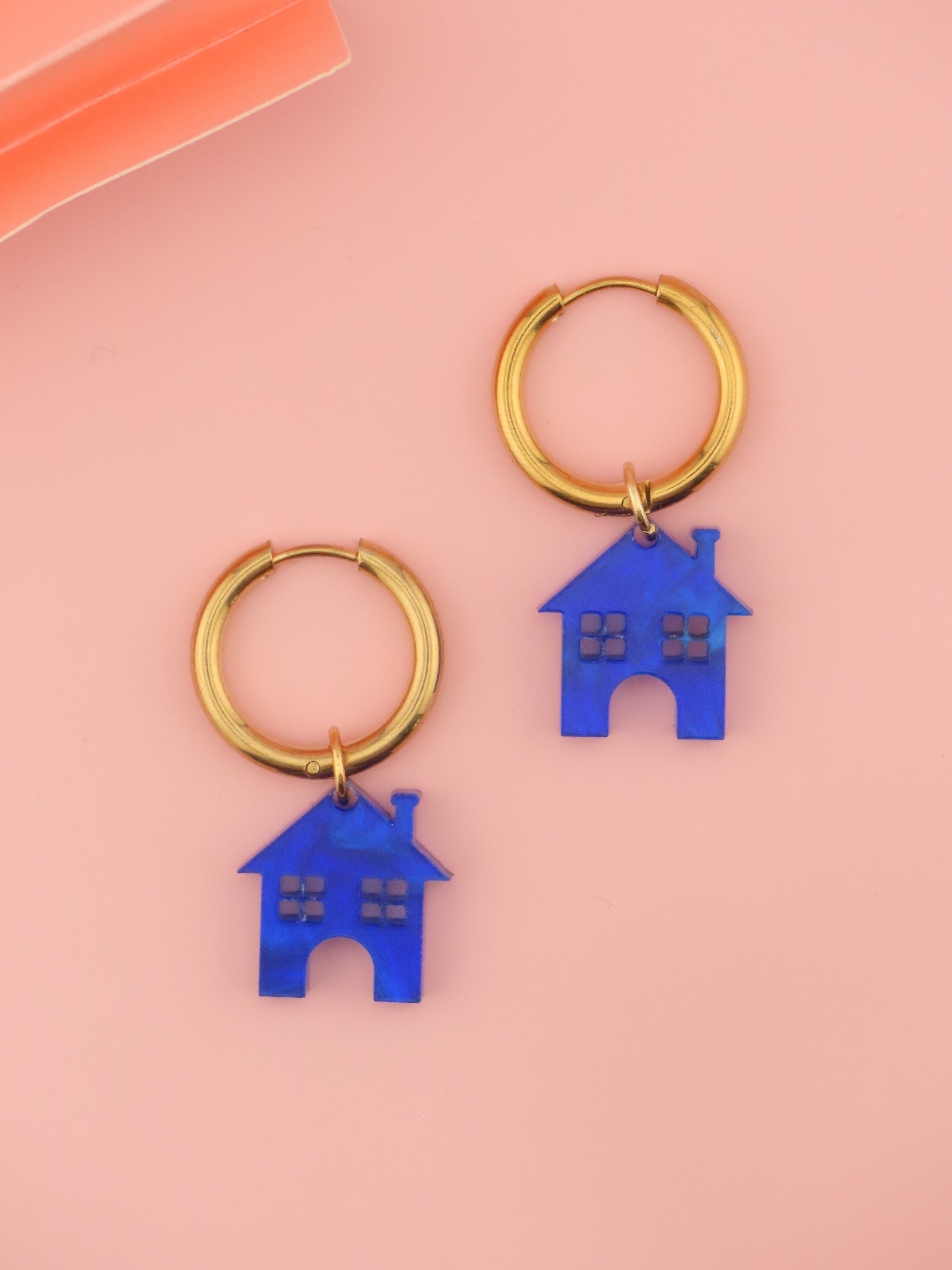 leichte edelstahlcreolen in gold mit kleinen hausanhaengern aus kobaltblauem acryl