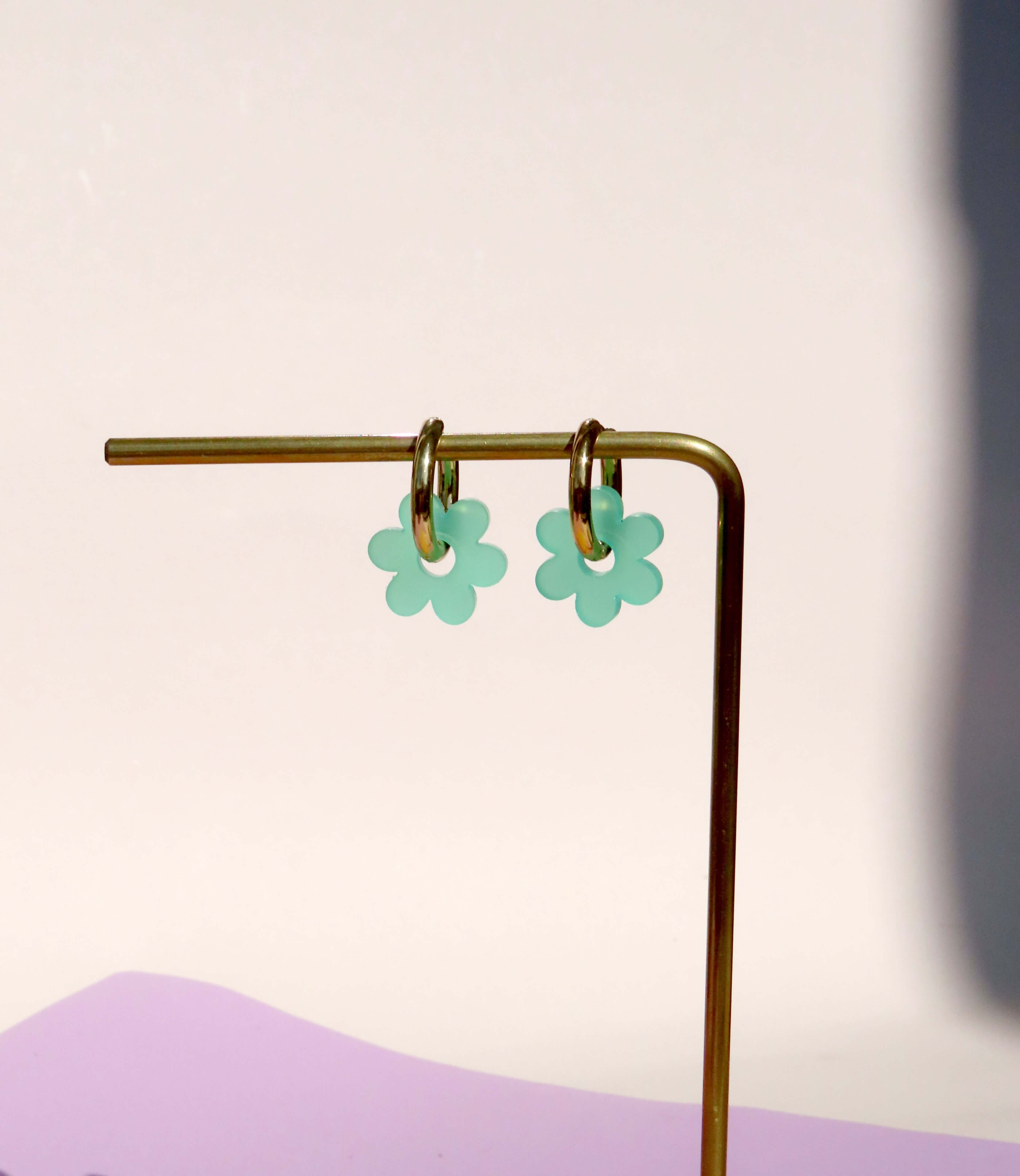 Leichte Hoops aus vergoldetem Edelstahl mit türkisfarbenem Acrylanhänger in Blumenform mit offener Mitte
