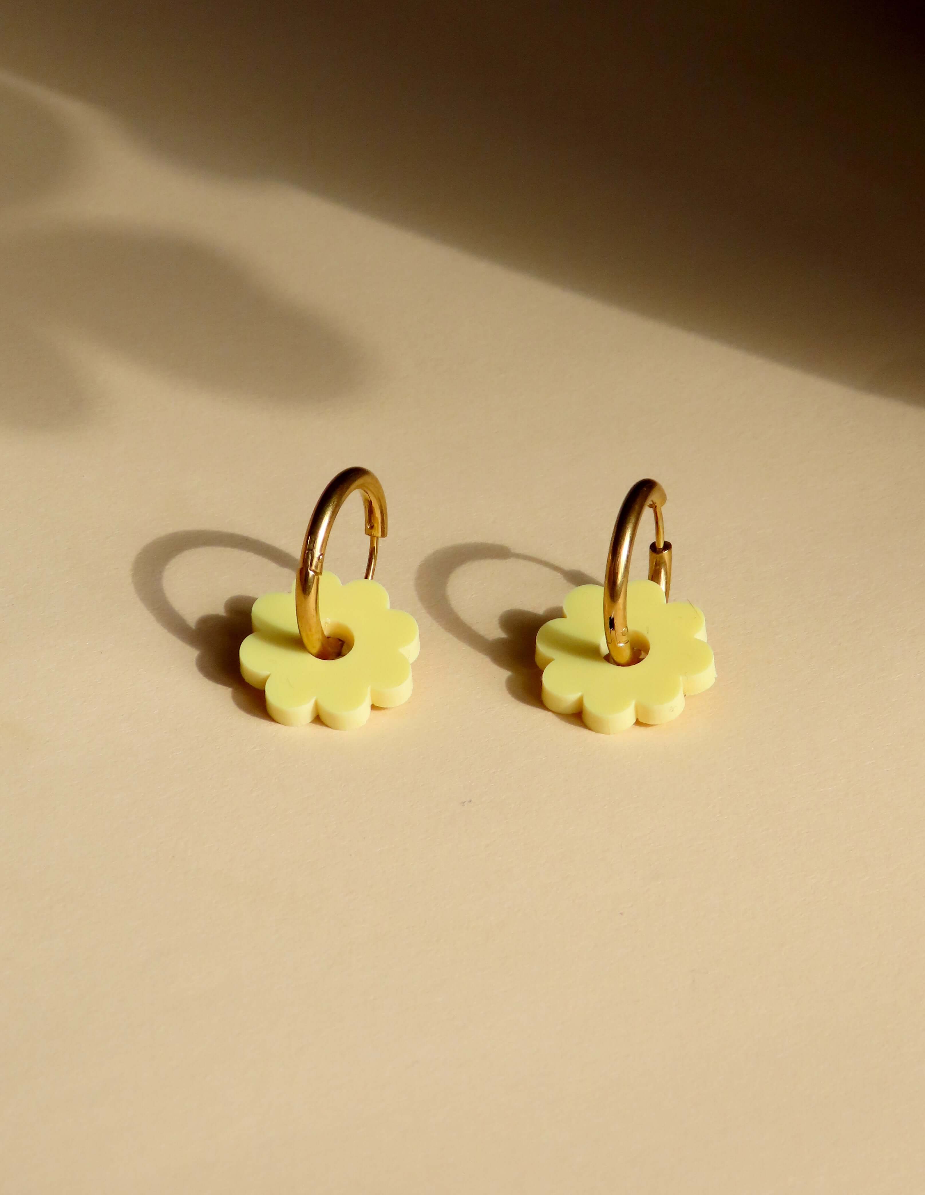Hellgelbe Acrylblüten an goldfarbenen Creolen aus Edelstahl, runde Form mit zarten Blütenblättern