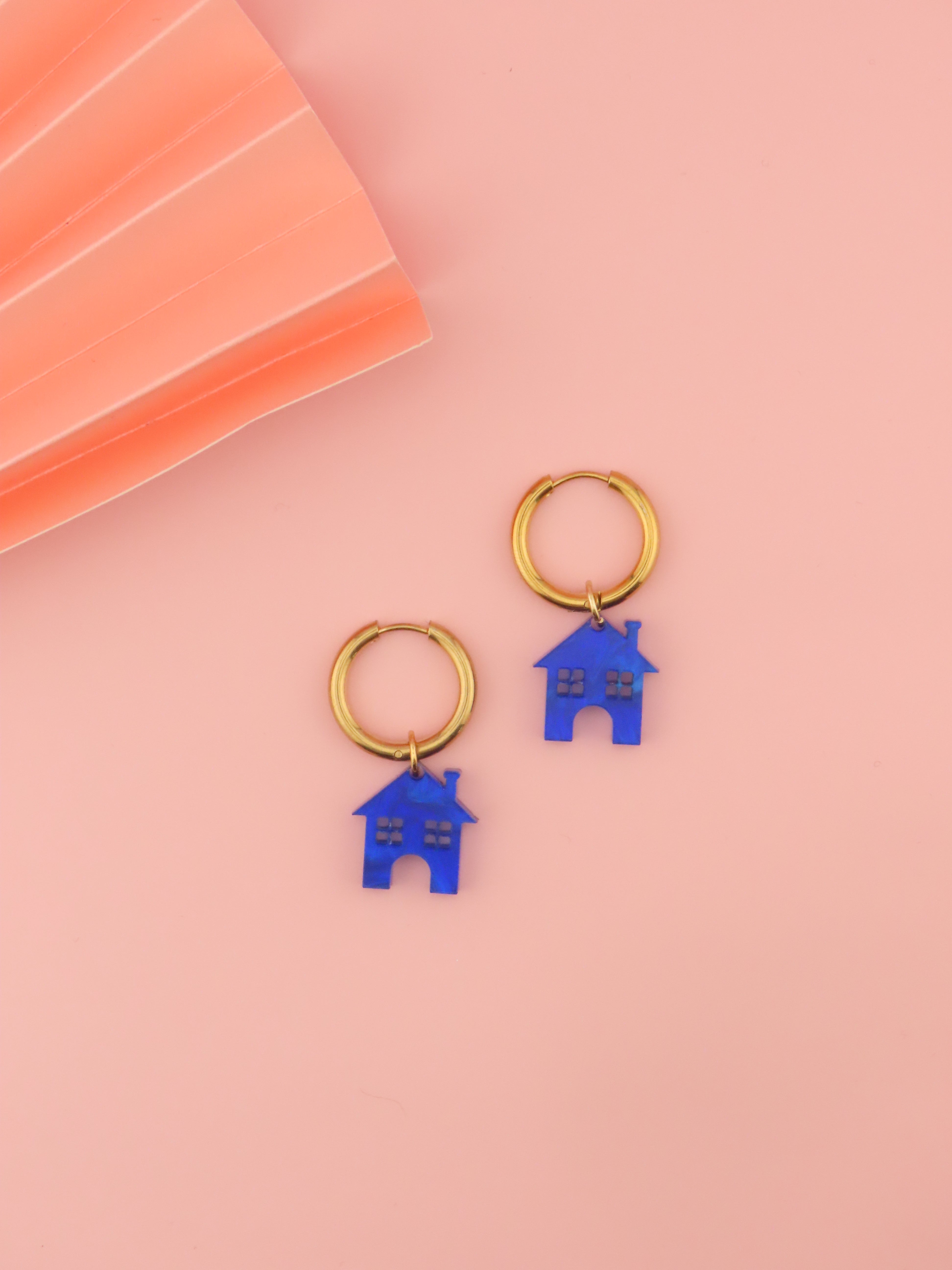 vergoldete edelstahlcreolen mit kobaltblauem acrylhaus-anhaenger in klarer, leicht schimmernder optik