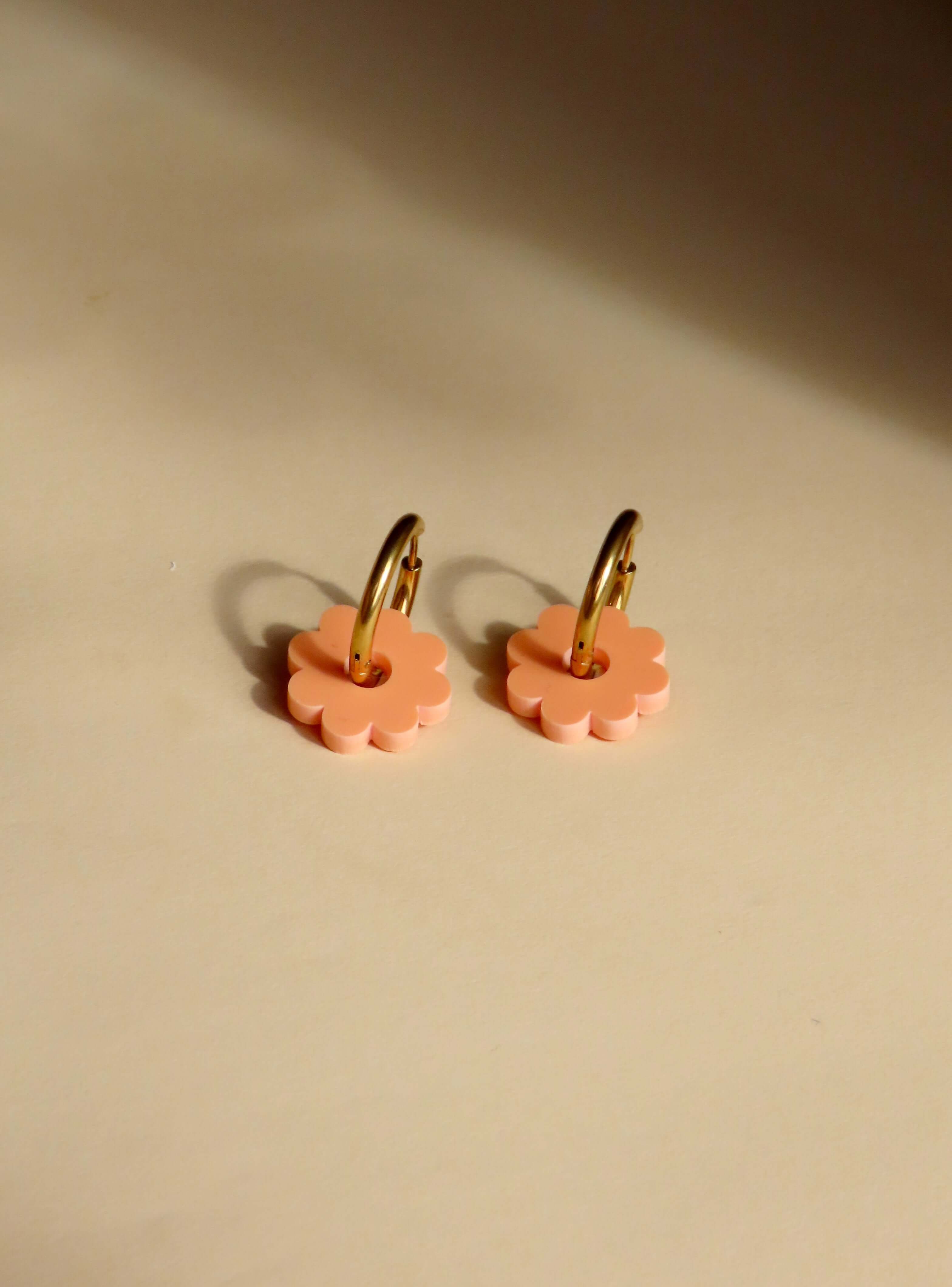 Runde Creolen aus vergoldetem Edelstahl mit pfirsichfarbener Acrylblüte als Anhänger