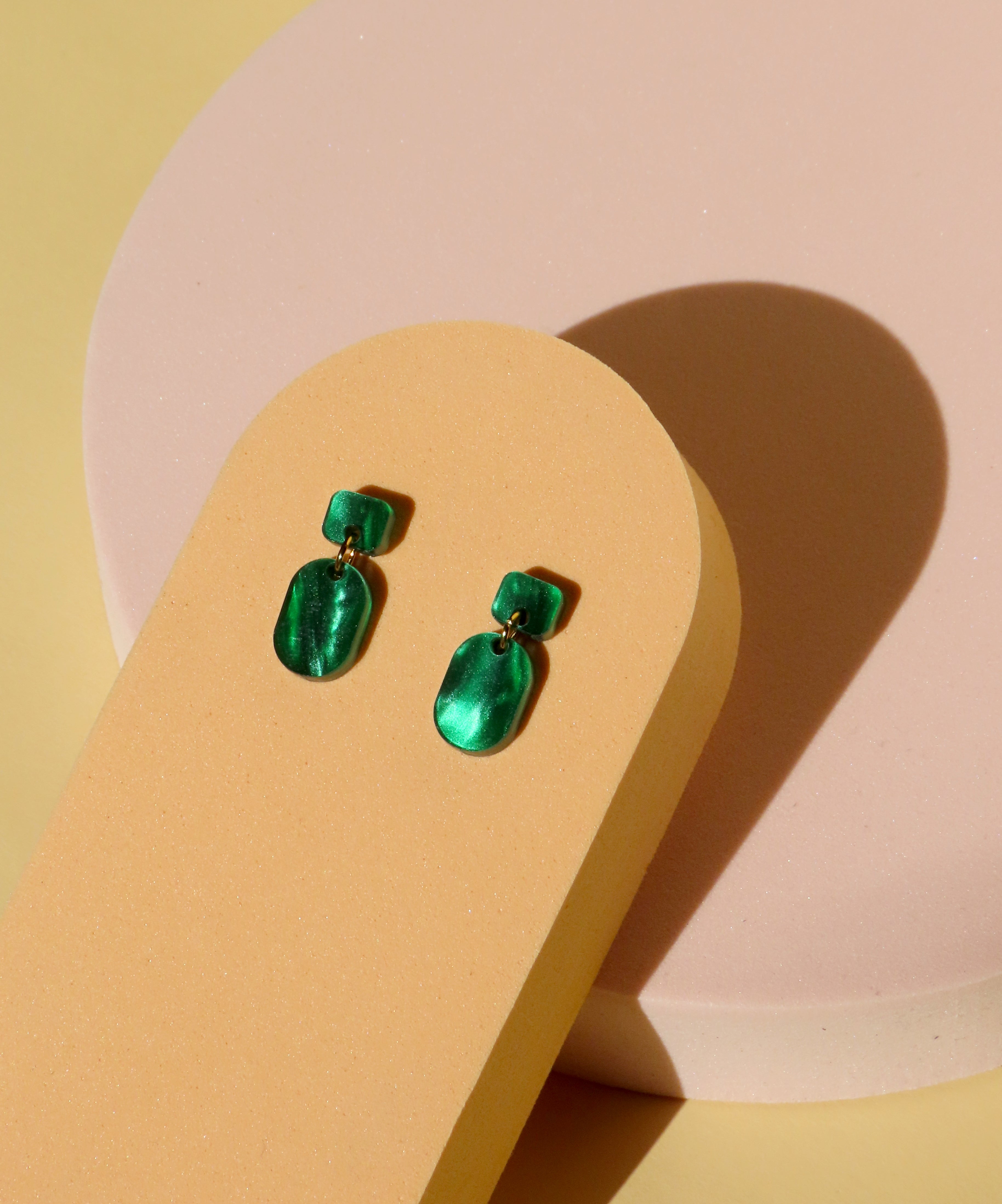 kleiner ohrring aus grünem acryl mit goldfarbener verbindung
