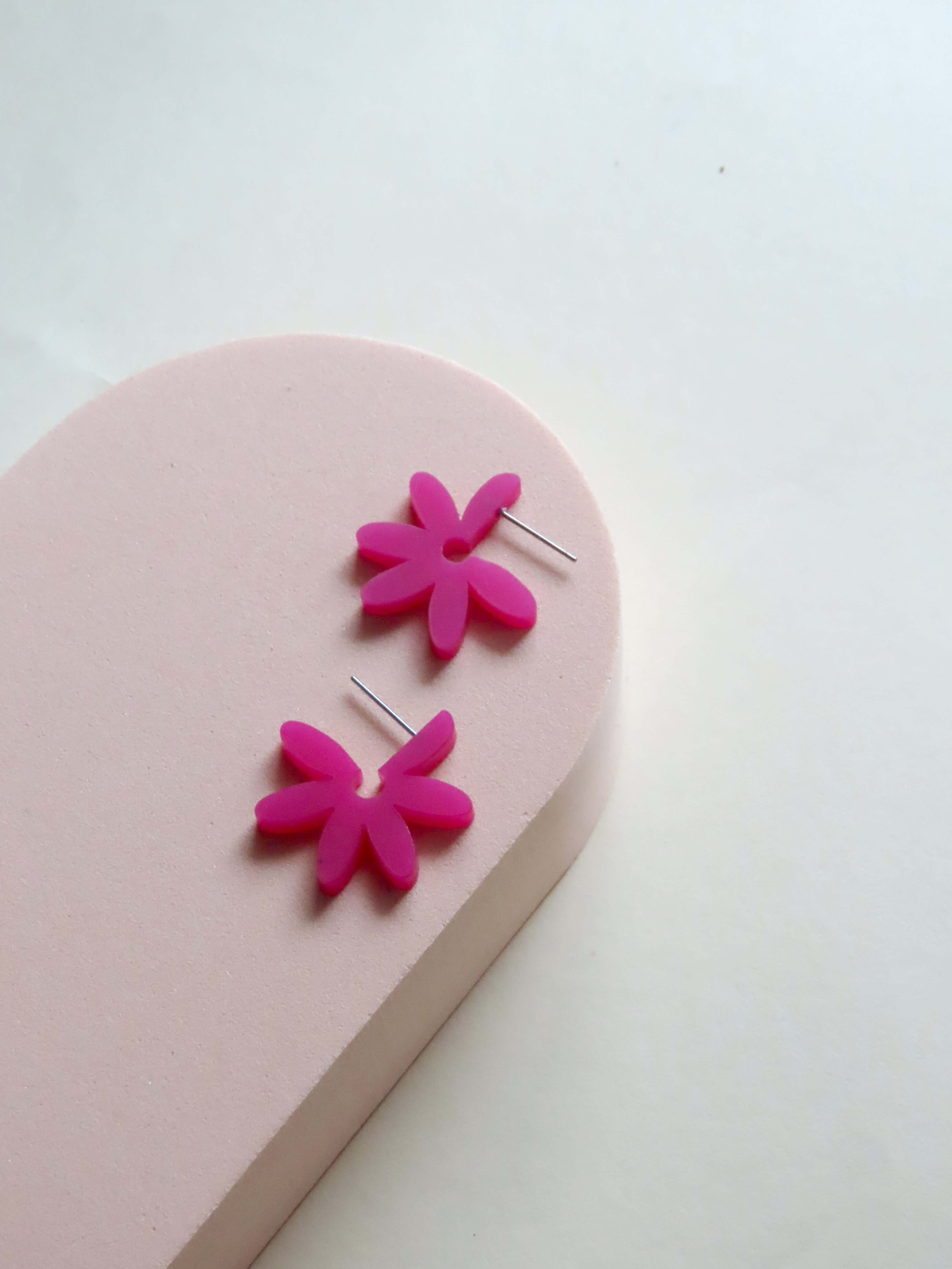 Runde Flower Creolen aus Acryl in Pink-Violett mit dynamisch angeordneten Blütenblättern und zarter Edelstahlfassung