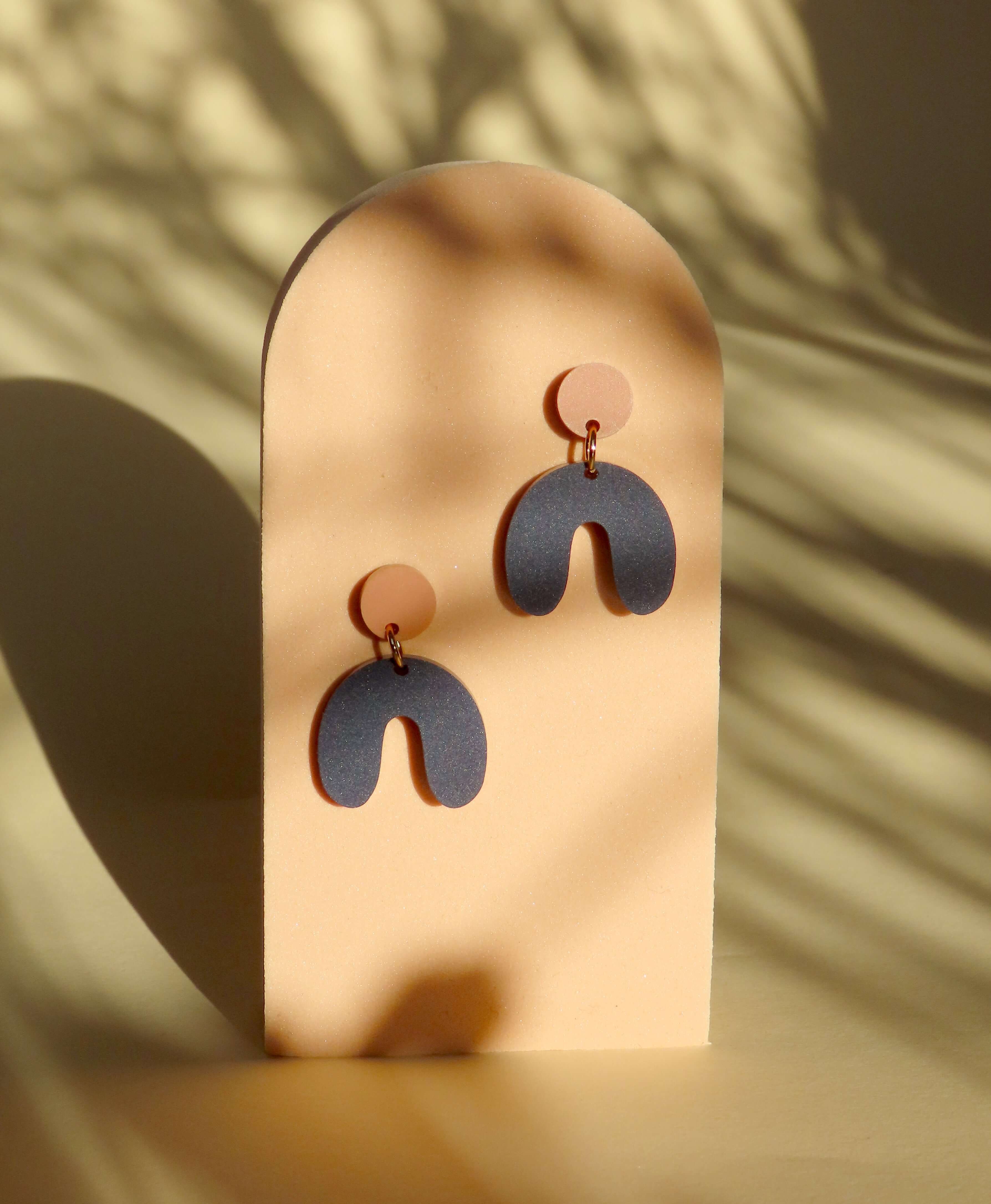 Design-Ohrringe mit geometrischem Look in Terracotta und Dunkelblau, bestehend aus runder und gebogener Form