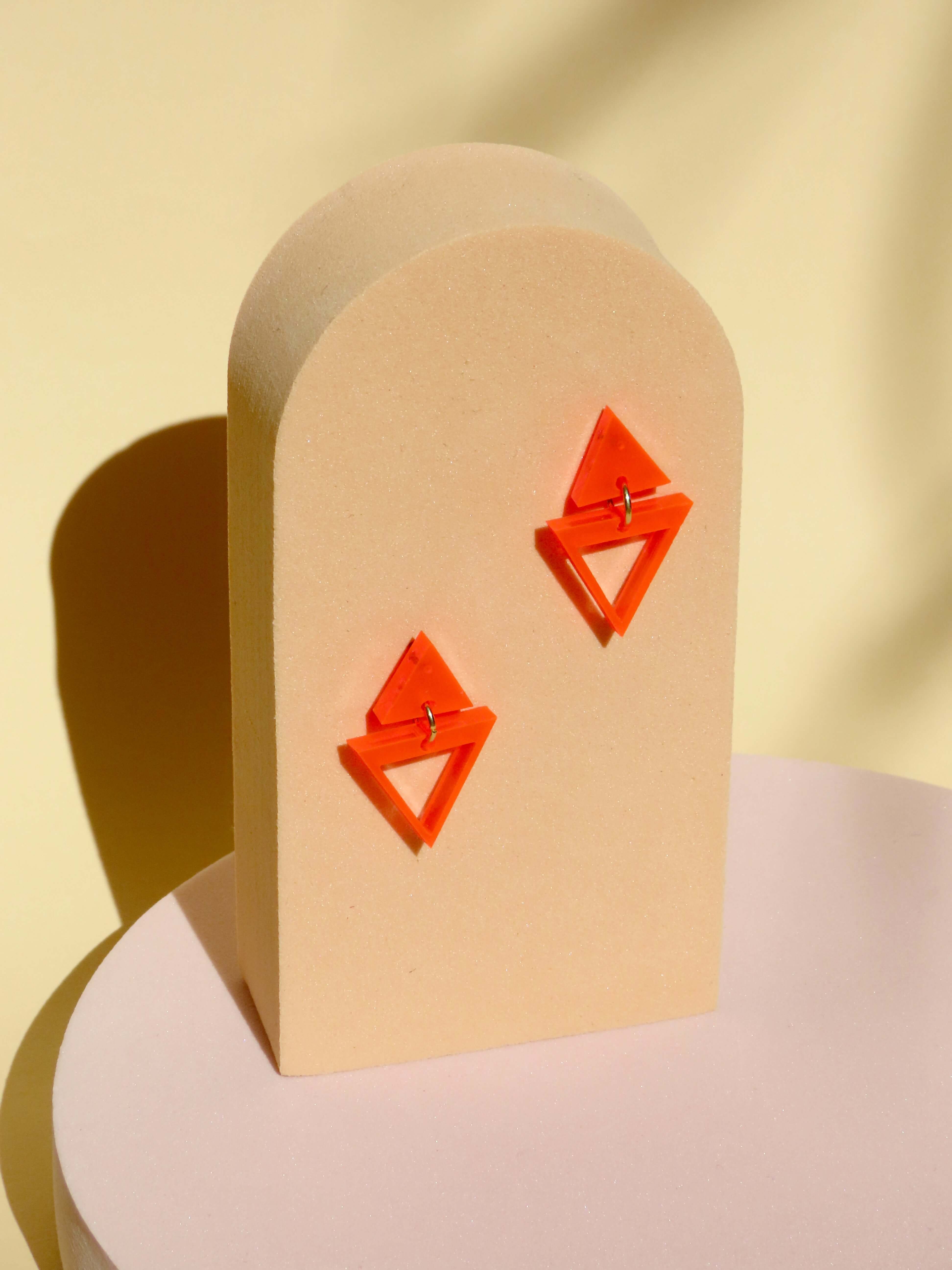 dreieckige acryl ohrhänger in neonorange mit edelstahl stecker, leichte geometrische form