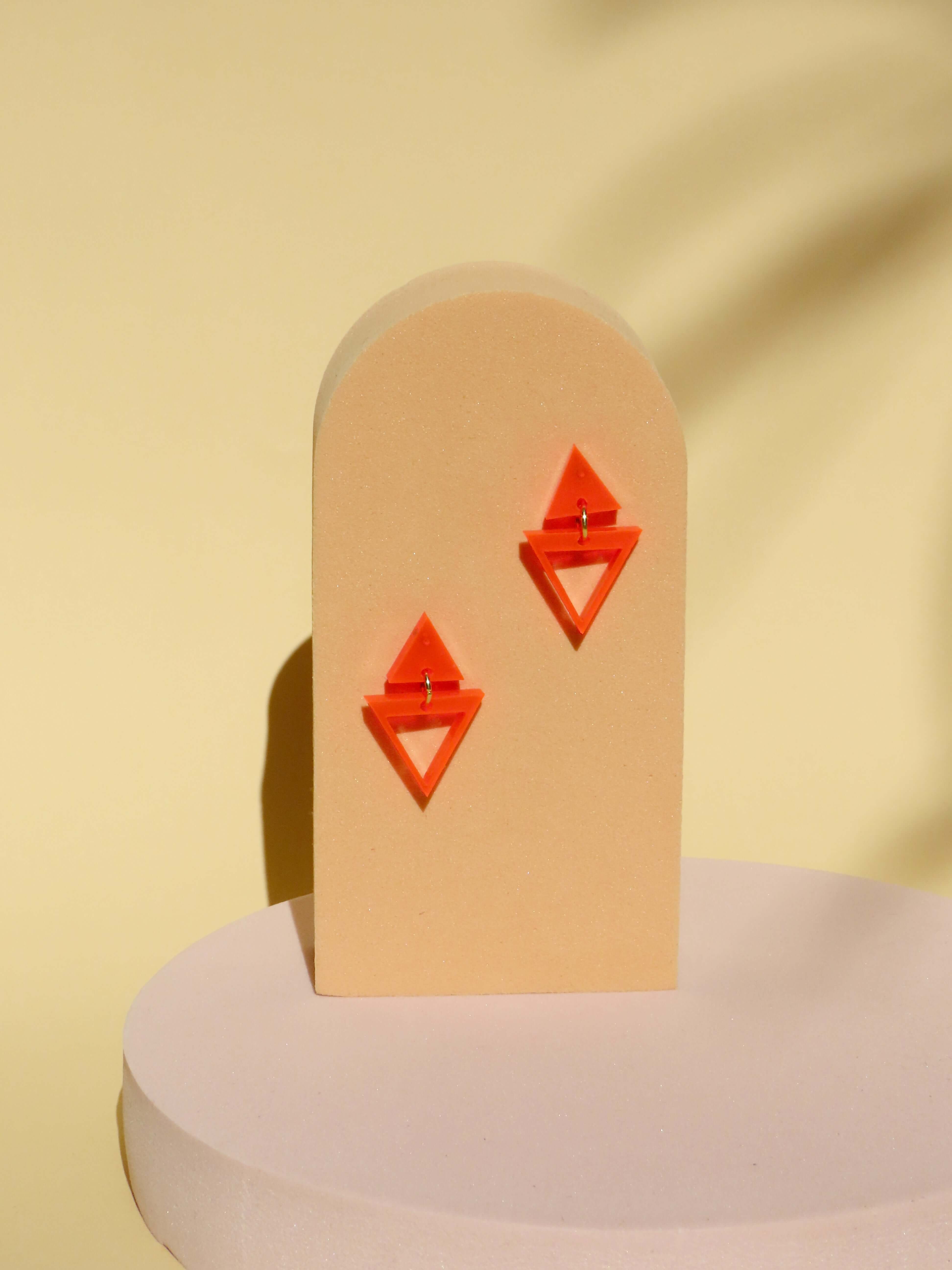 paar ohrhänger aus transparentem neonorangefarbenem acryl in doppelter dreiecksform mit edelstahlsteckern