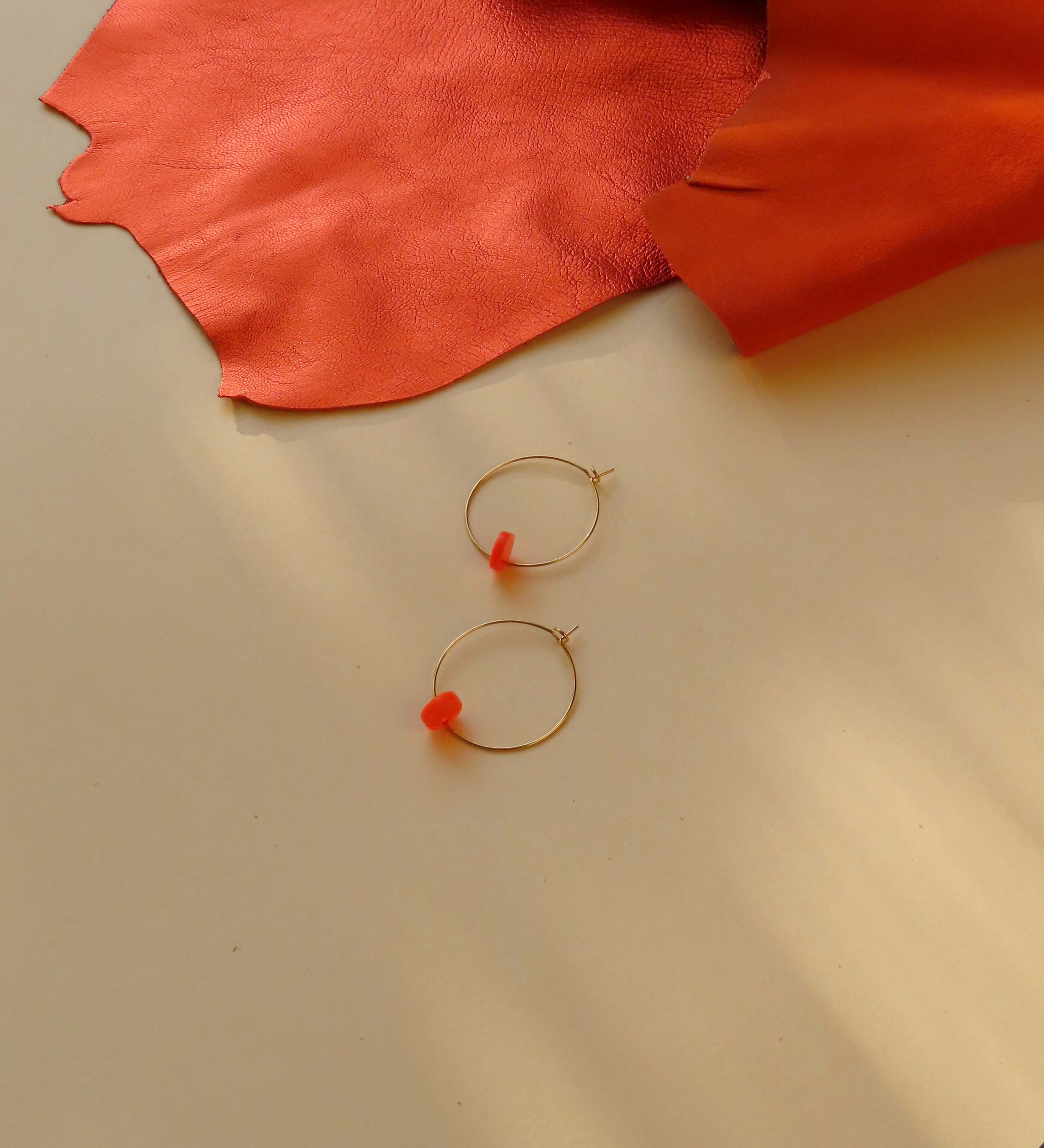 Handgefertigte Hoops aus Edelstahl mit zentralem neonorangefarbenem Acryl-Element
