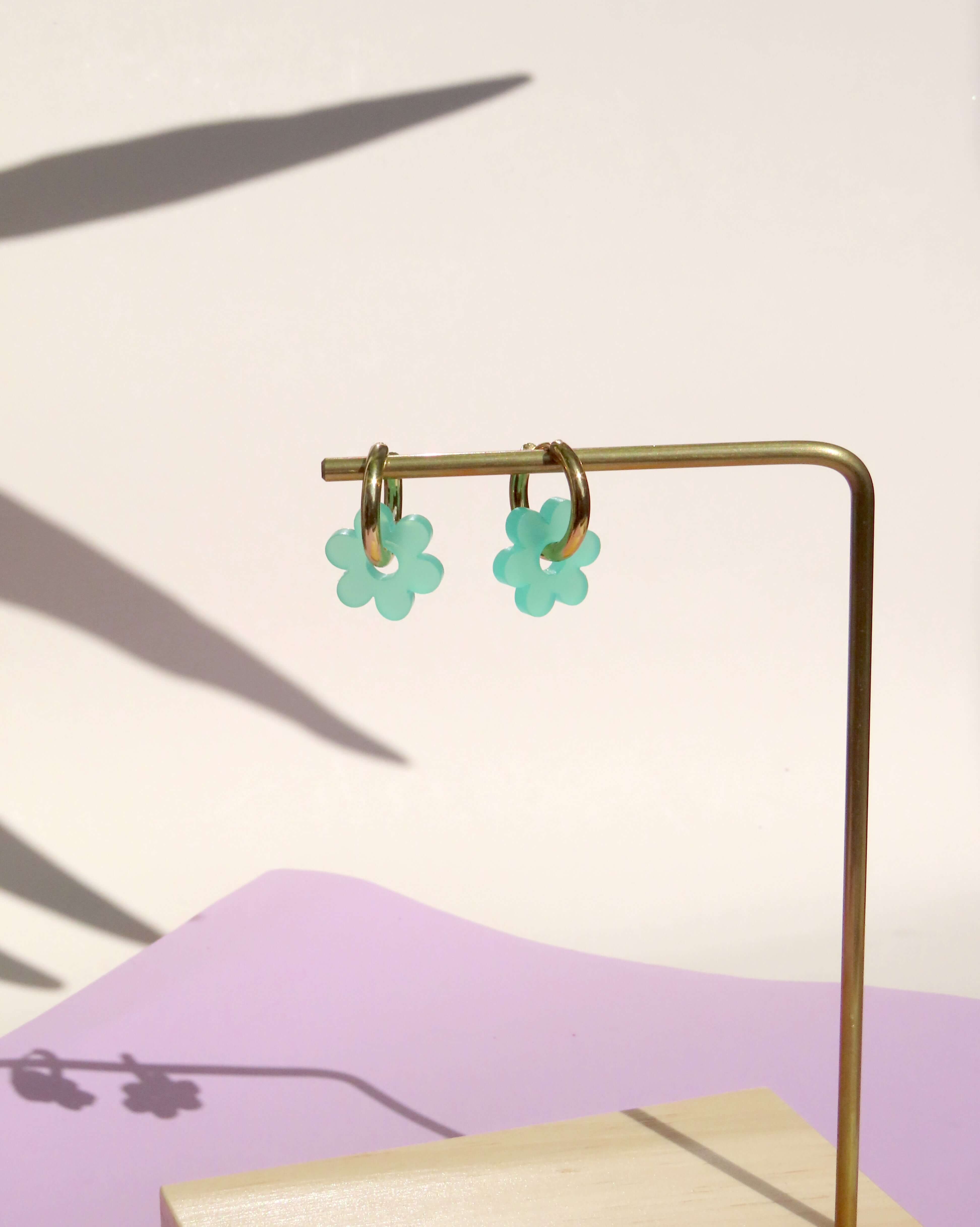 Türkise Flower Hoops bestehend aus goldfarbenen Creolen und floralen Acrylblüten mit sechs abgerundeten Blütenblättern