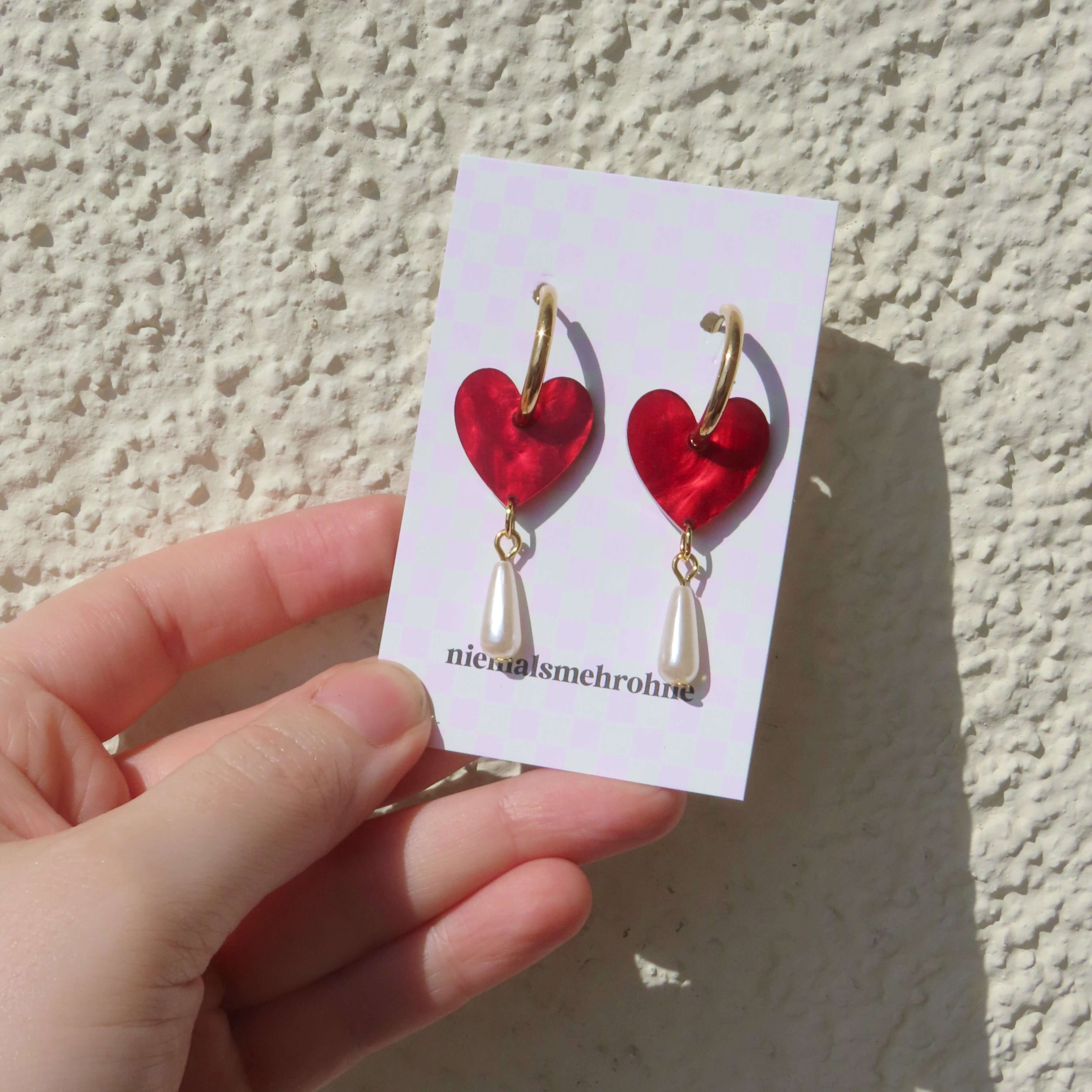 Glänzend rote Acryl-Herzohrringe mit goldfarbener Creole und weißem Tropfenanhänger