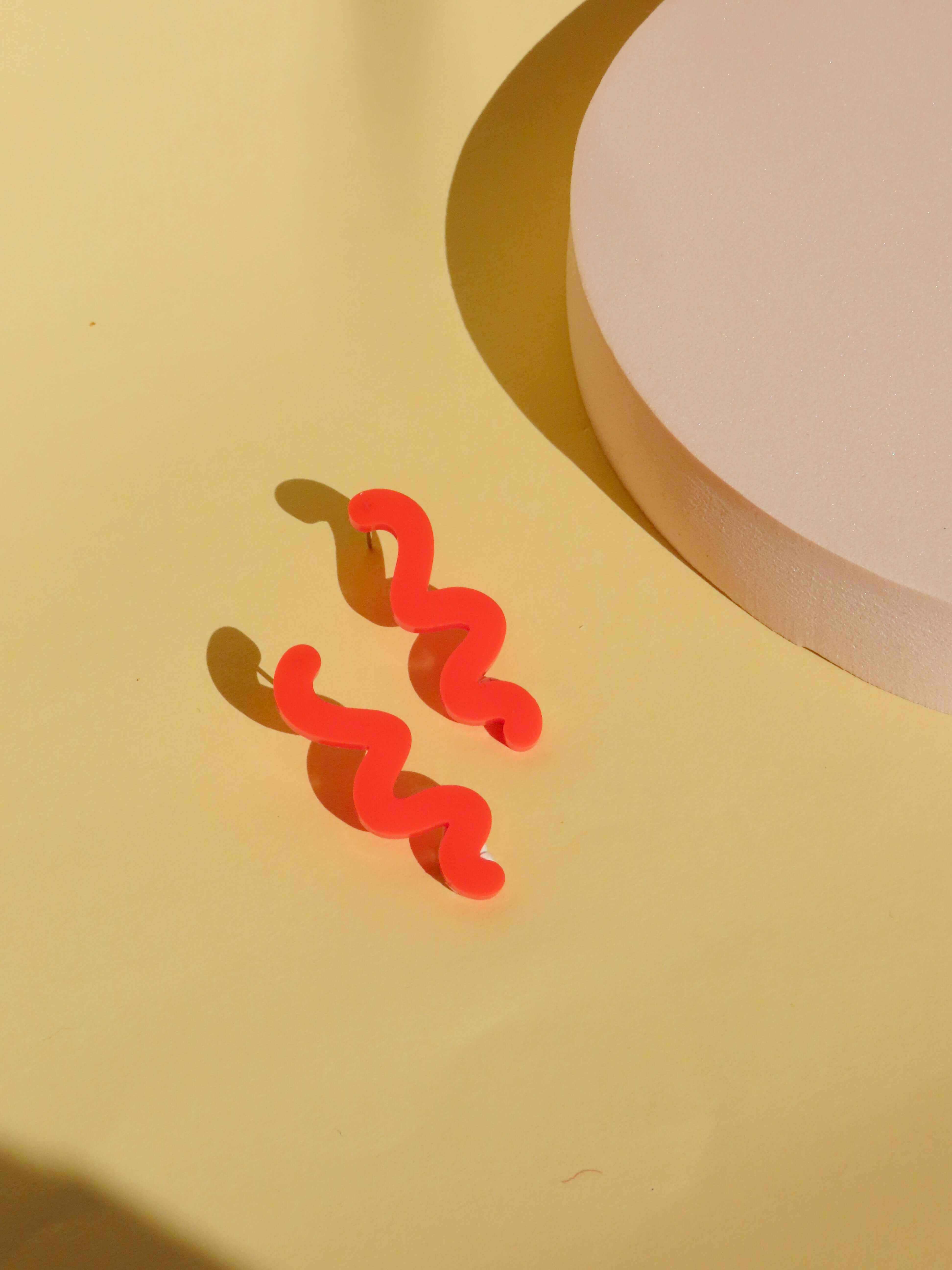 Ohrstecker aus glänzendem Acryl in intensivem Feuerrot mit schwungförmigem Design
