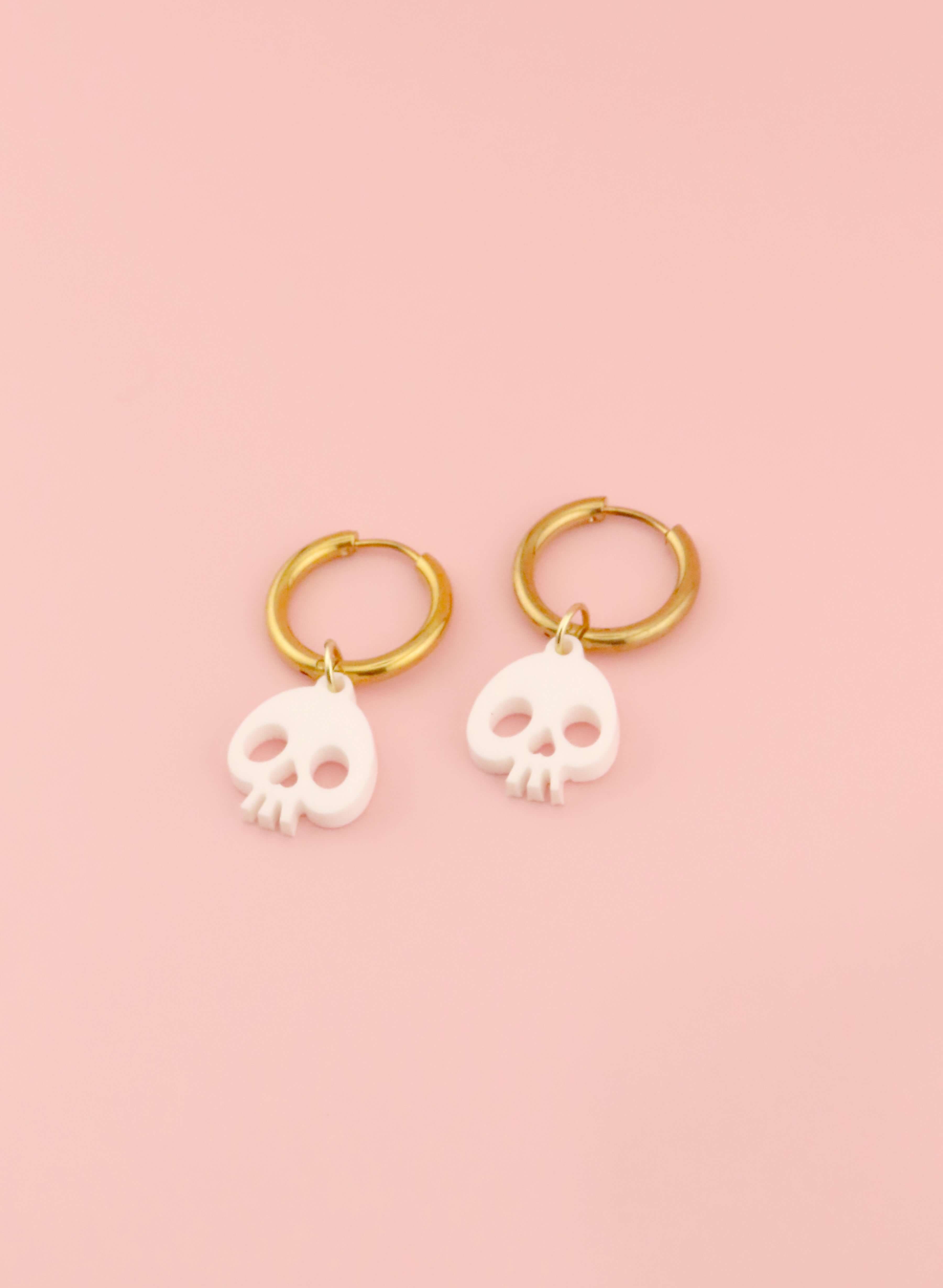 Skull-Creolen mit weißen Anhängern aus Acryl und goldenen Ringen, minimalistisch und markant