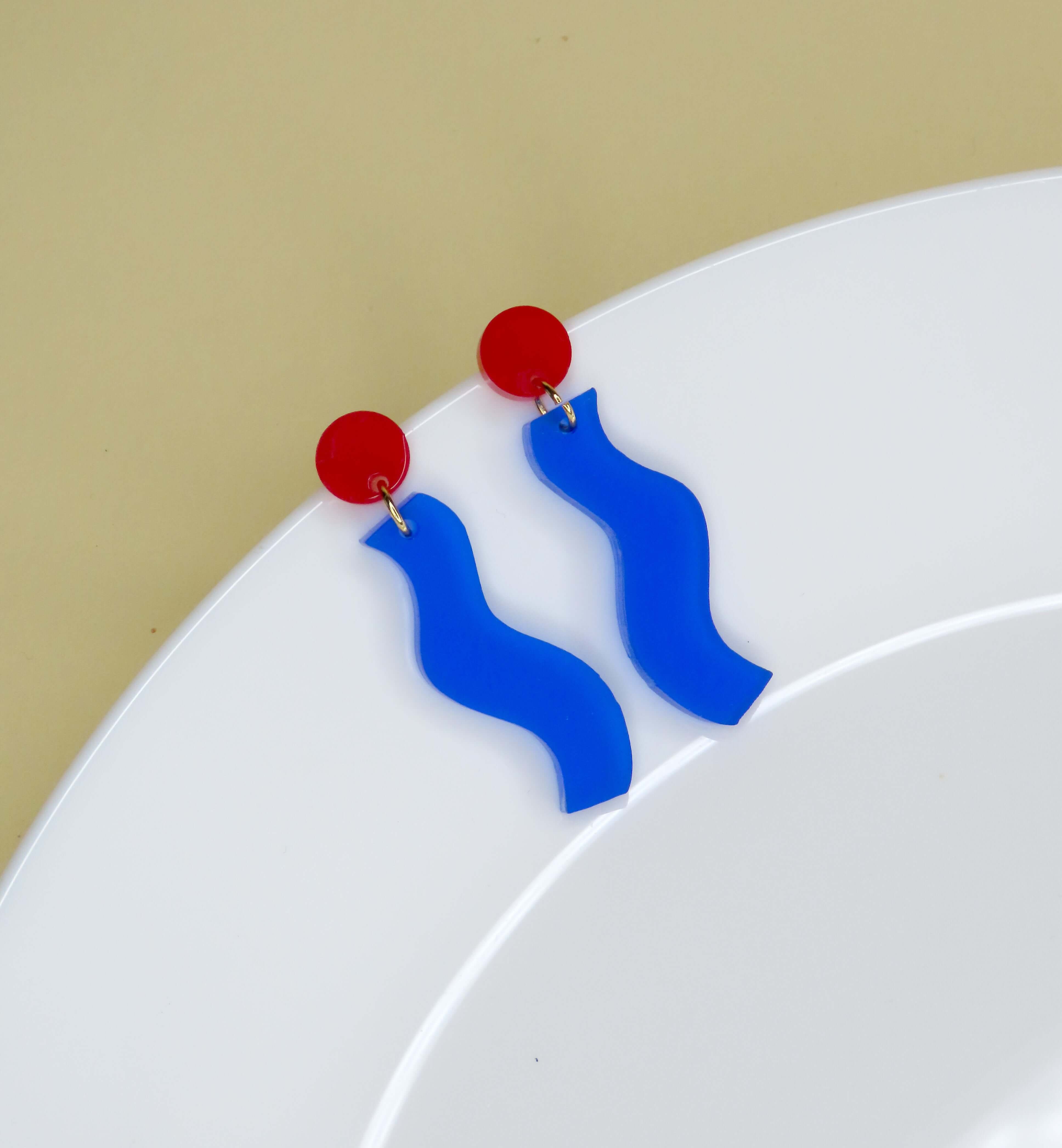 Ohrhänger mit runder roter Oberseite und wellenförmigem Anhänger in tiefem Blau