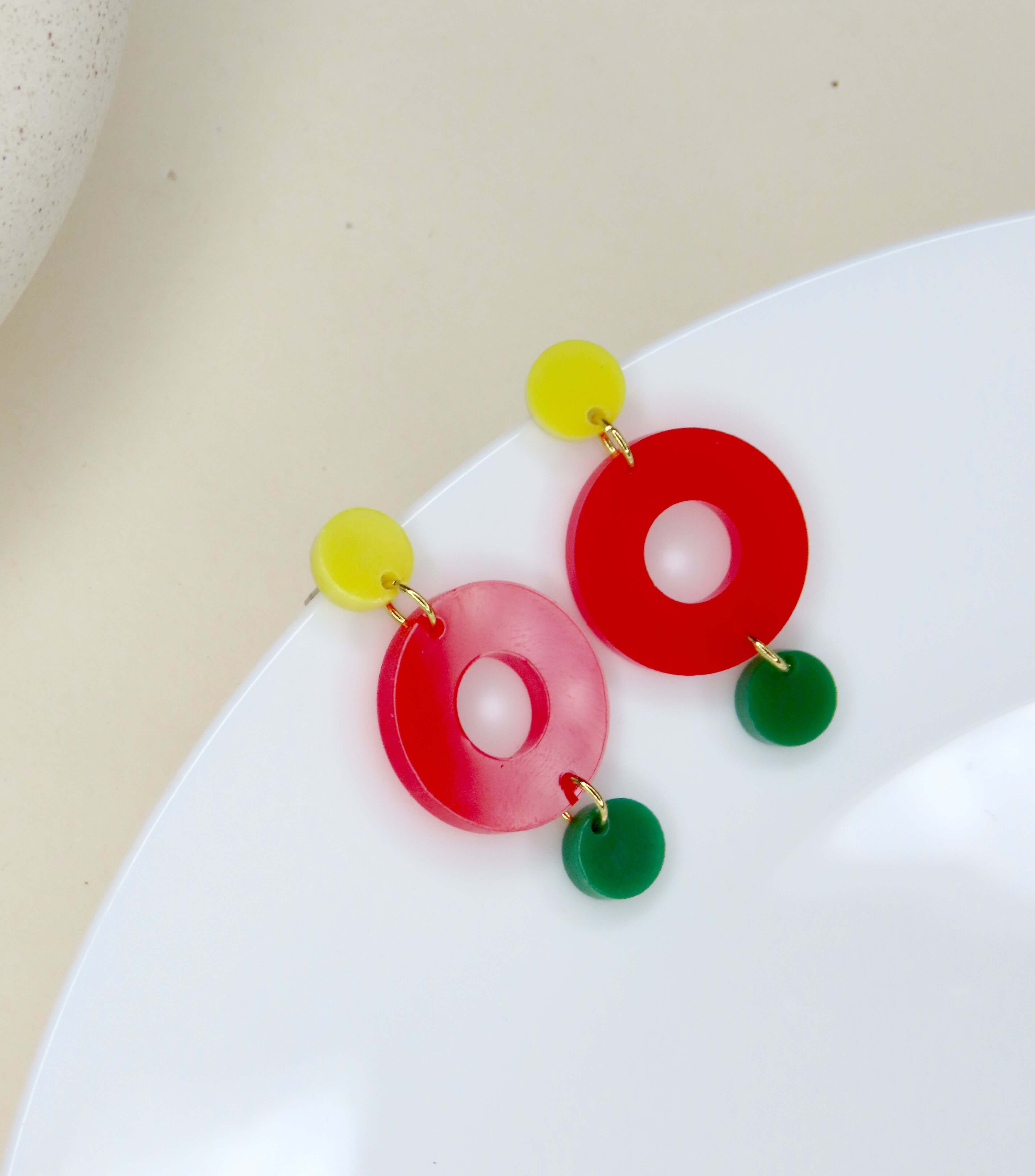 Leichte Acryl Ohrringe mit drei runden Elementen in Gelb, Rot und Froschgrün, verbunden durch goldfarbene Ringe