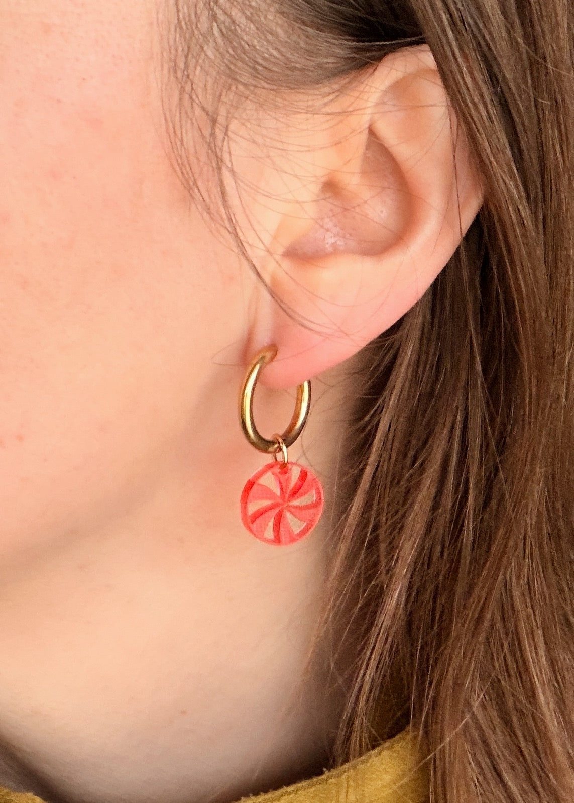 runde goldcreolen mit rotem transparentem acryl anhaenger in bonbonartiger form