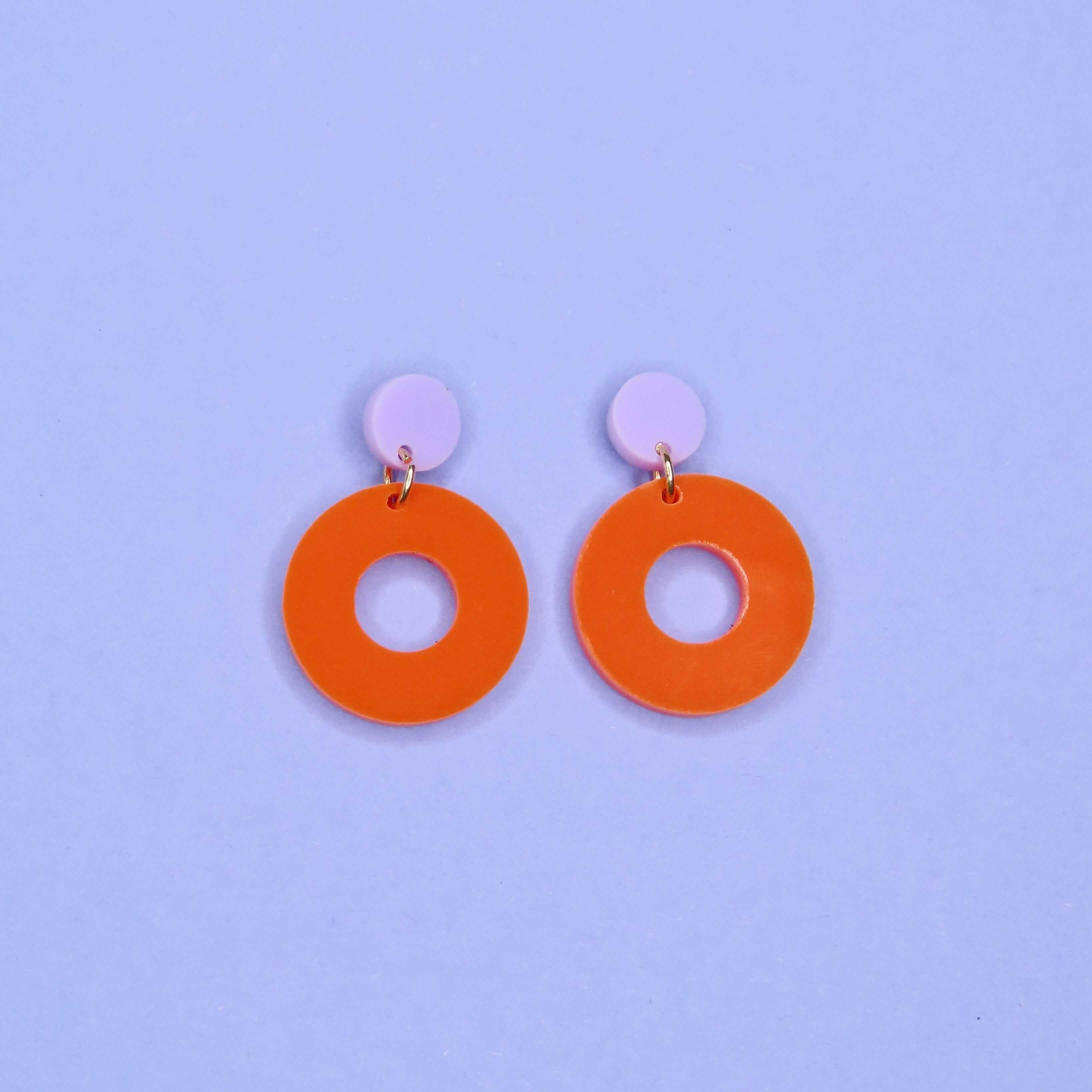 Moderne Ohrringe aus Acryl mit fliederfarbenem Kreisstecker und auffälligem orangefarbenem Ring