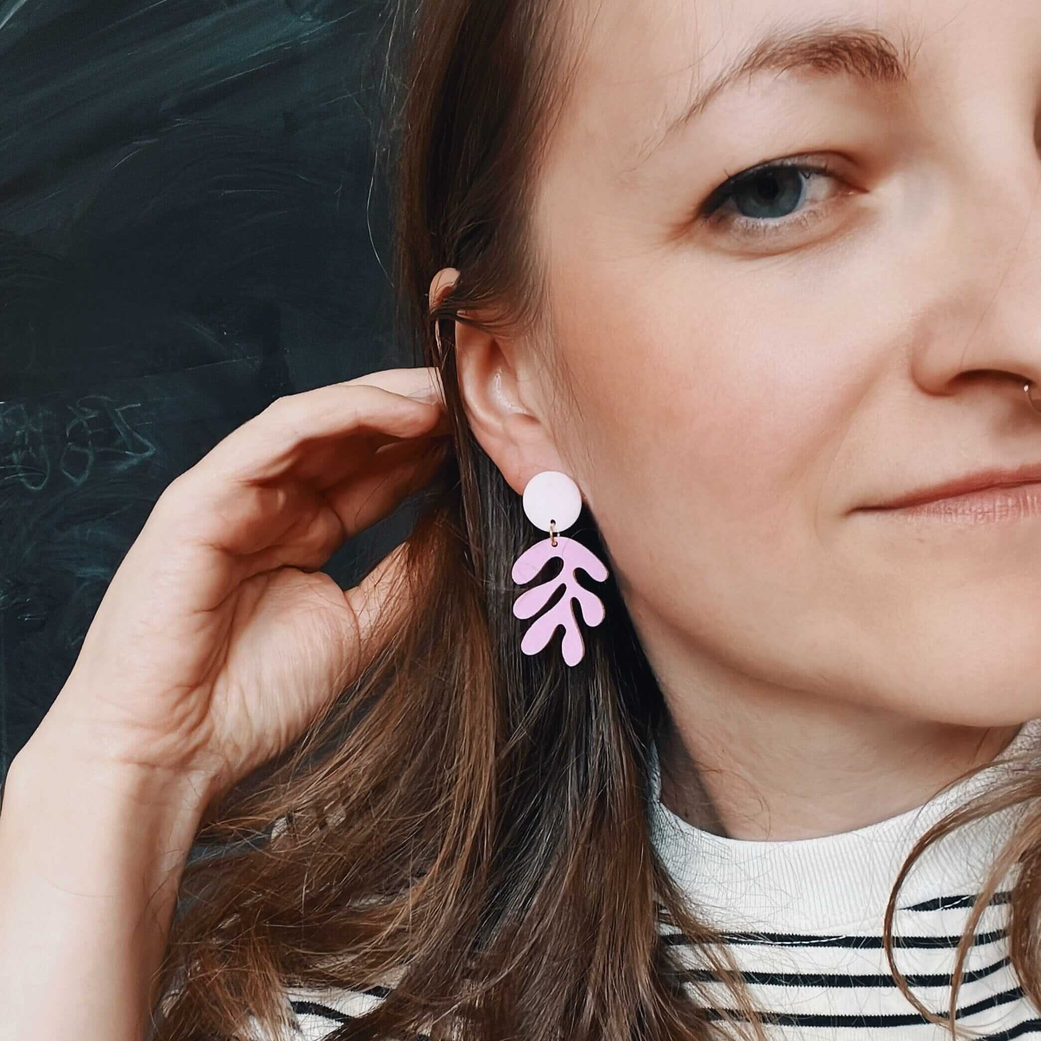 handgefertigter ohrring aus acryl: rosa rundteil und lila blattförmiger anhänger