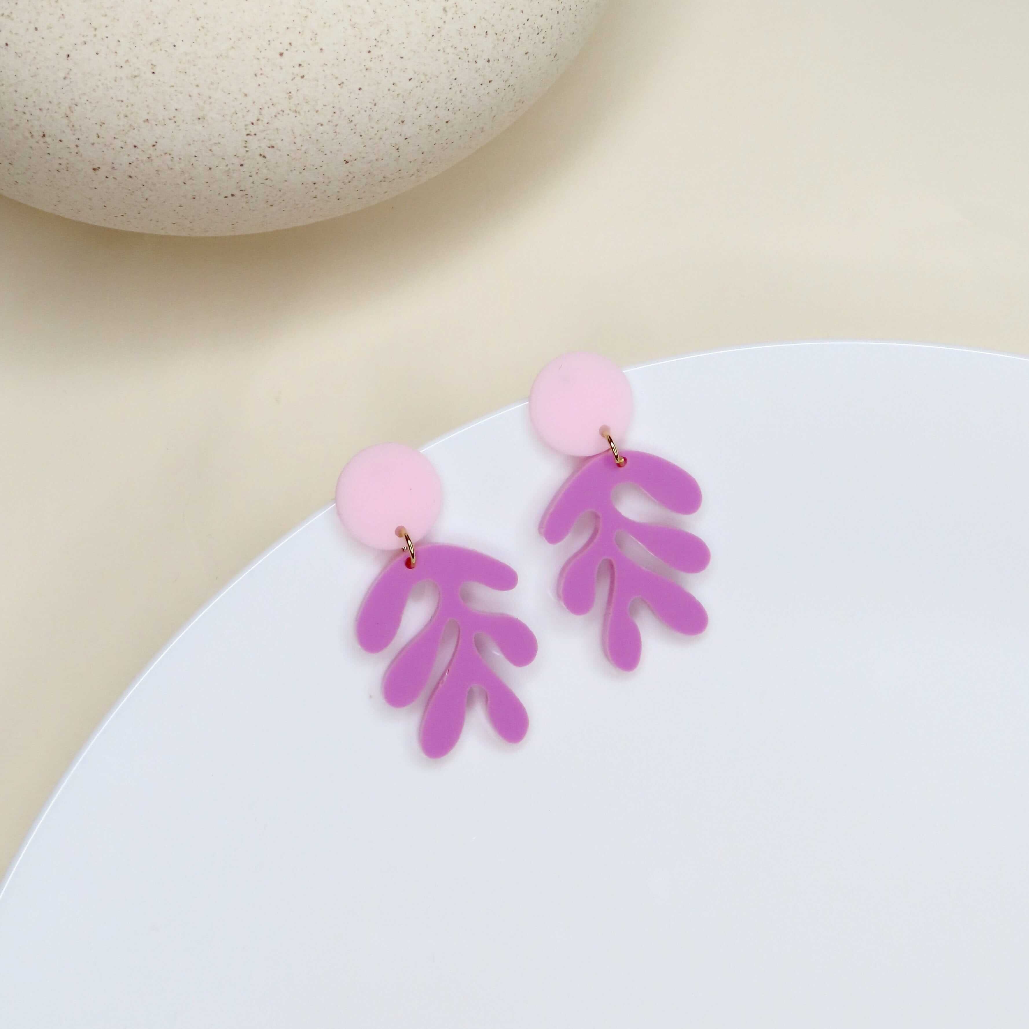 rosa-acryl-ohrring mit rundem stecker und lila-blattförmigem anhänger