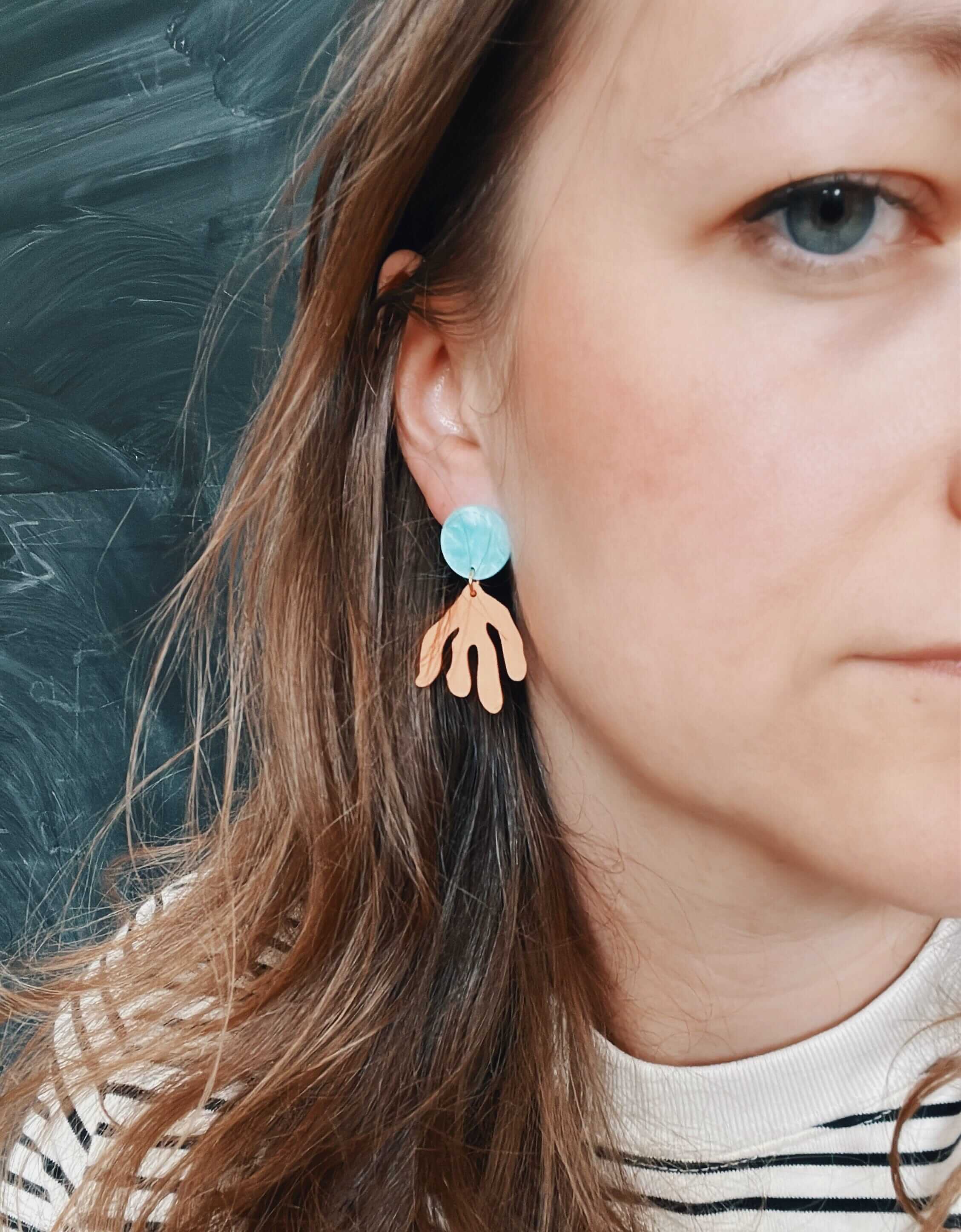 kunstvolle ohrringe aus acryl und edelstahl-stecker: hellblau marmorierte scheibe plus pfirsich zweig-anhänger