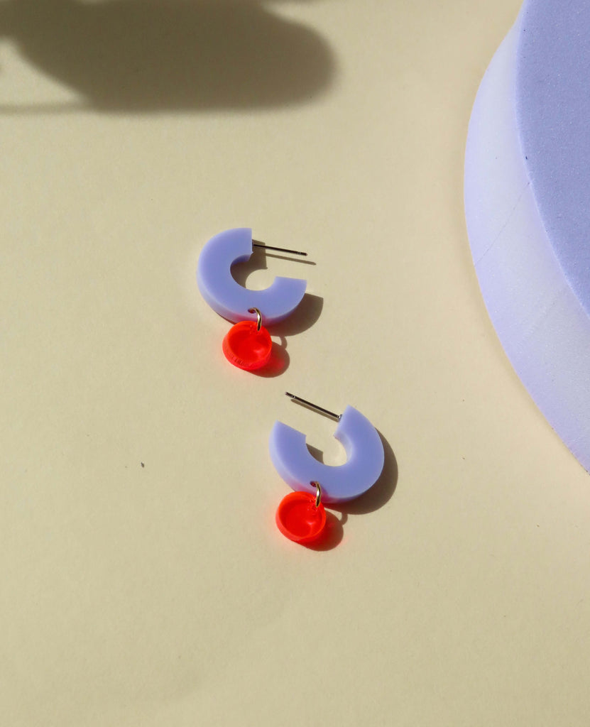 Kleine Design-Creolen in Flieder mit leuchtend rotem Dot aus Acryl