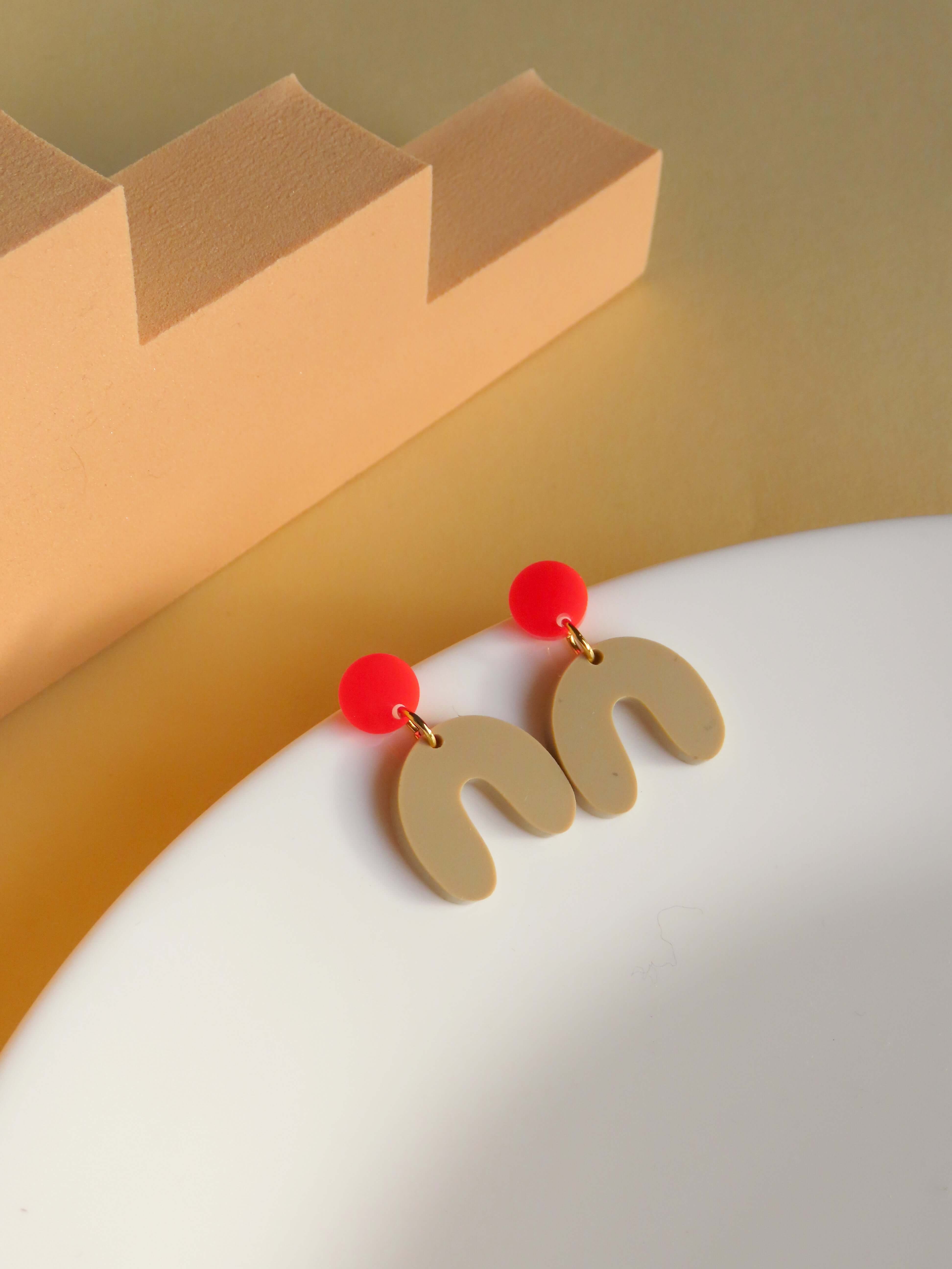 Handgefertigte Acryl-Ohrringe in moderner Bogenform, kombiniert mit Edelstahlstecker, Farben Feuerrot und Beige