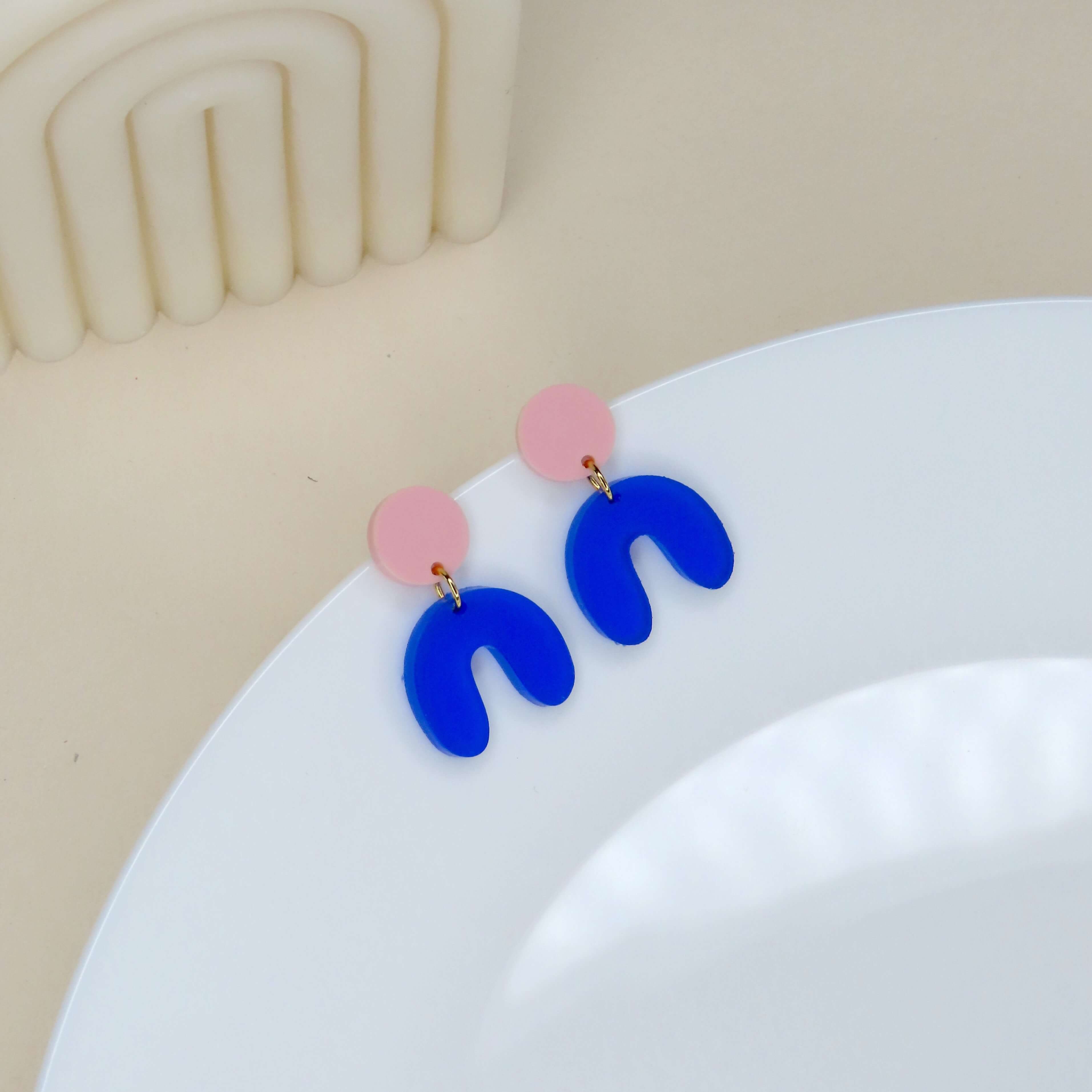 Statement-Ohrringe aus Acryl in Hellrosa und Blau mit geschwungener Bogenform
