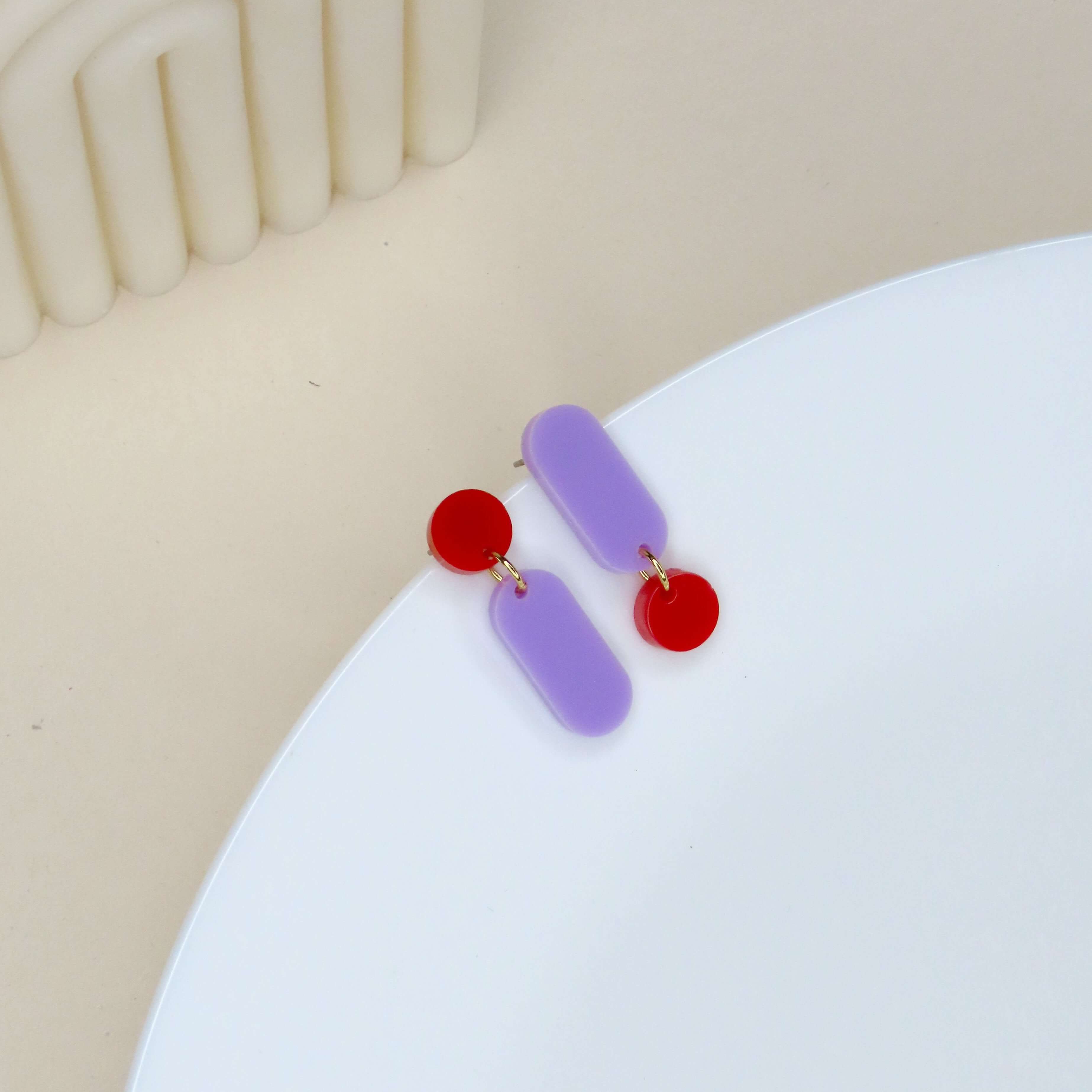 Asymmetrische Acryl-Ohrringe in knalligem Rot und zartem Flieder mit Edelstahl-Stecker
