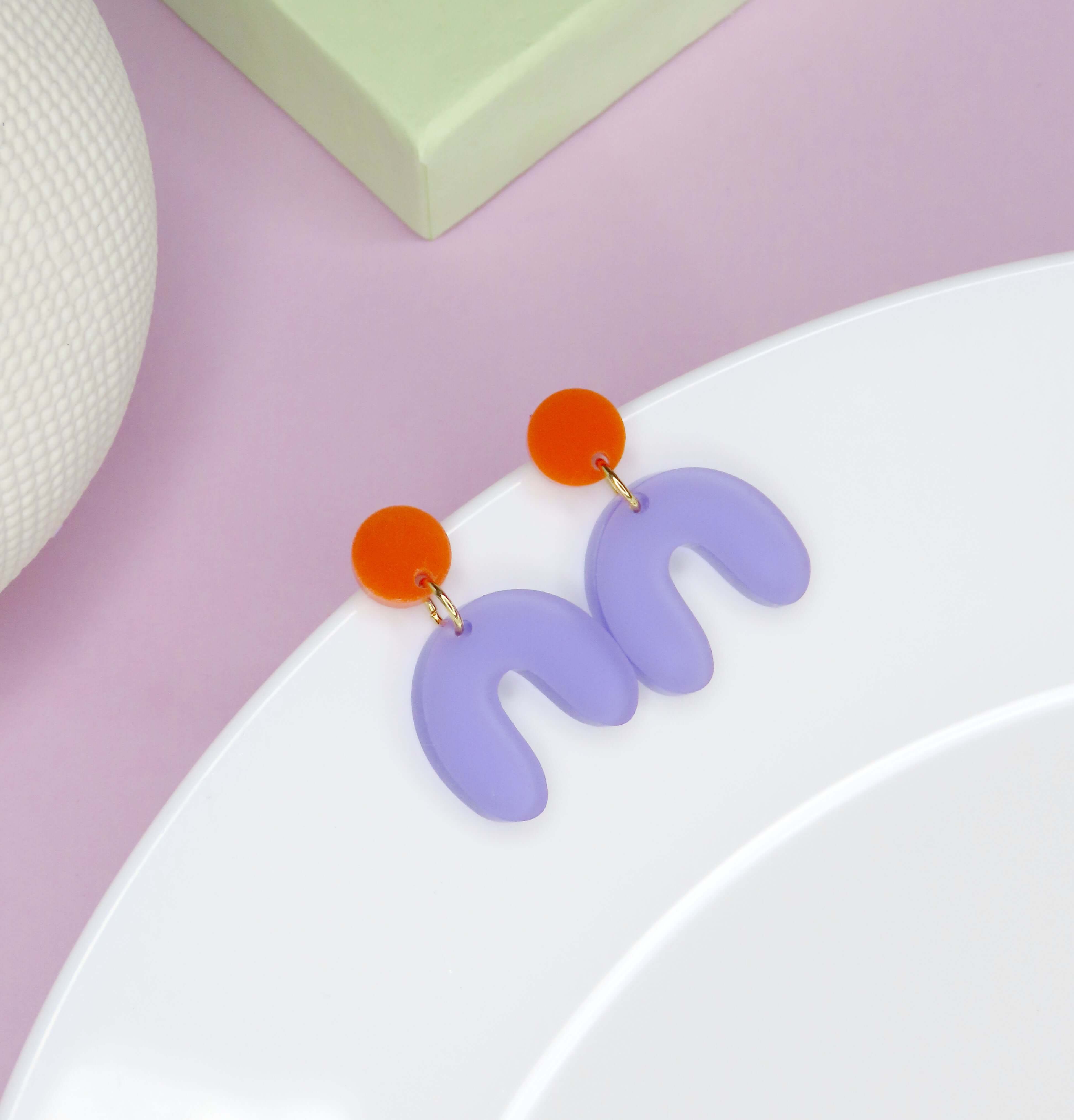 Handgefertigte Acryl-Ohrringe mit orangefarbenem Kreisstecker und geschwungenem lilafarbenem Anhänger