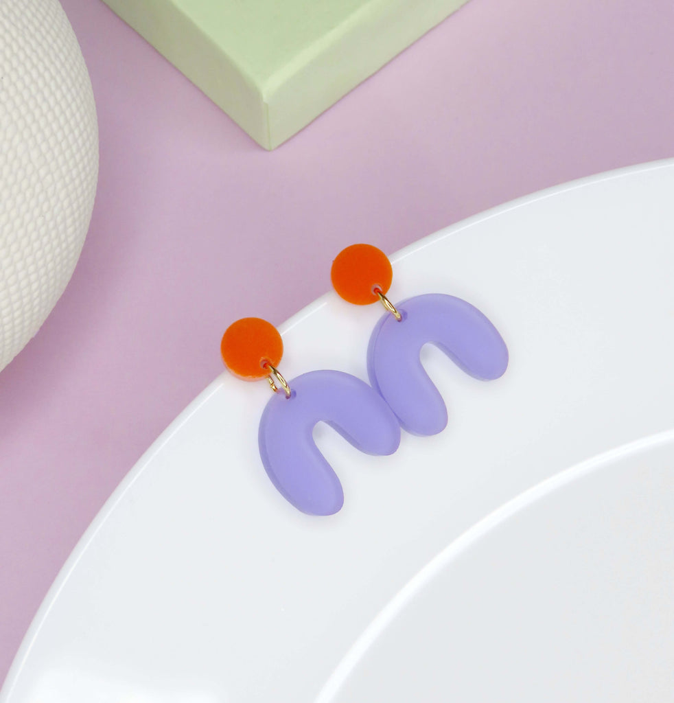Handgefertigte Acryl-Ohrringe mit orangefarbenem Kreisstecker und geschwungenem lilafarbenem Anhänger