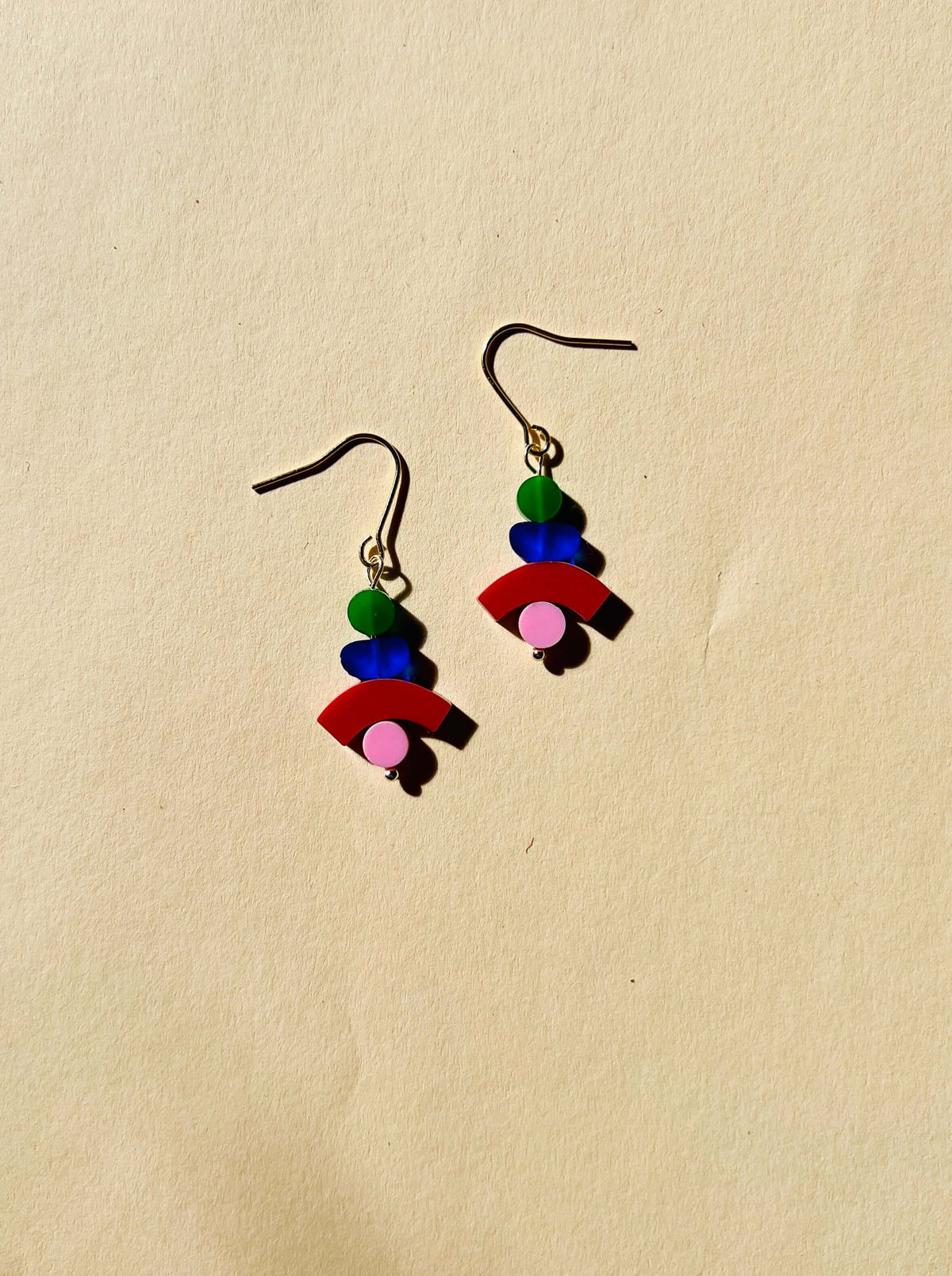 Bunte Cairns Ohrhänger mit geometrischen Acrylformen in Grün, transparentem Blau, Rot und Rosa