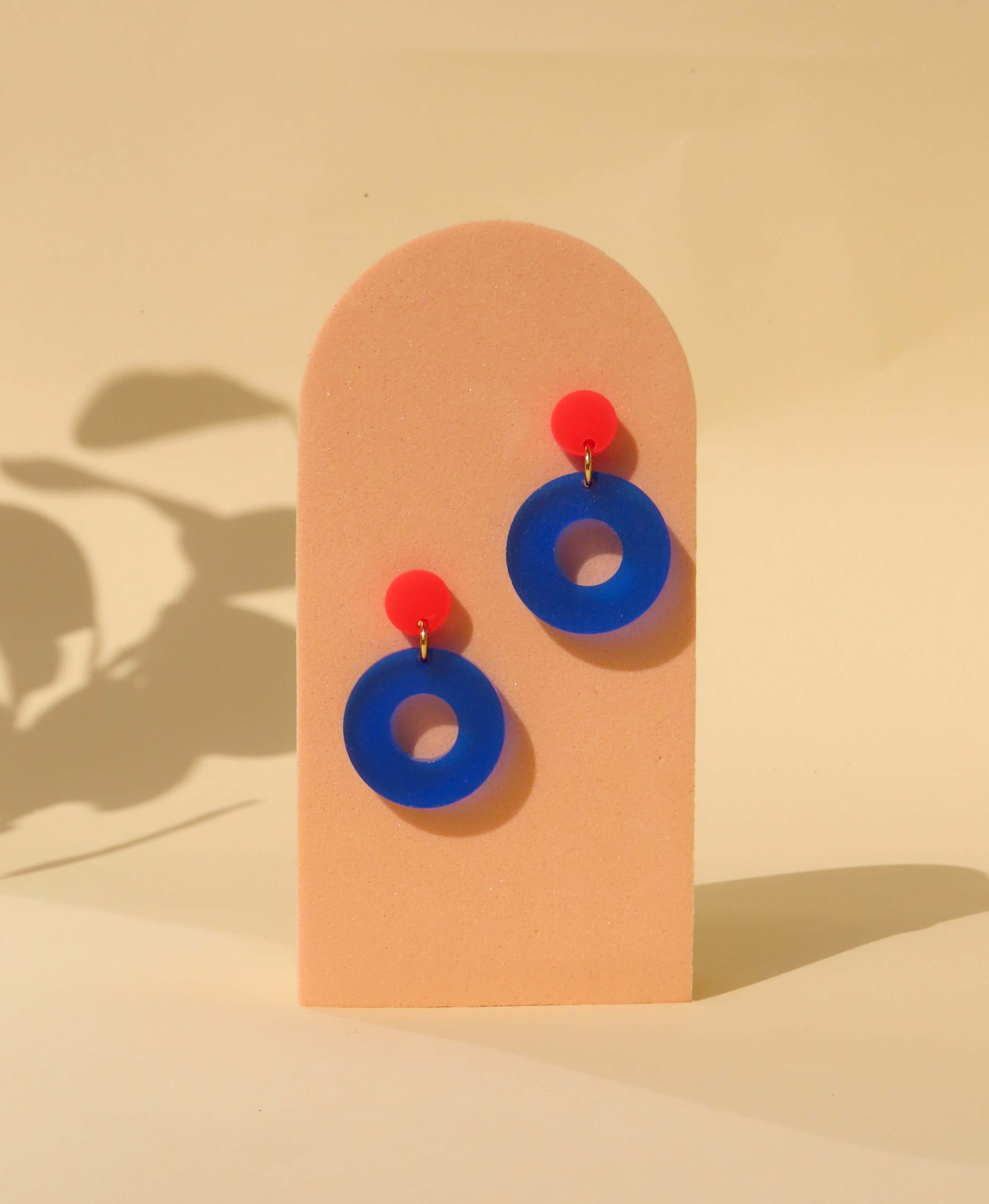 runde Acryl-Ohrstecker in kräftigem Feuerrot und Tintenblau mit Kreisform-Design