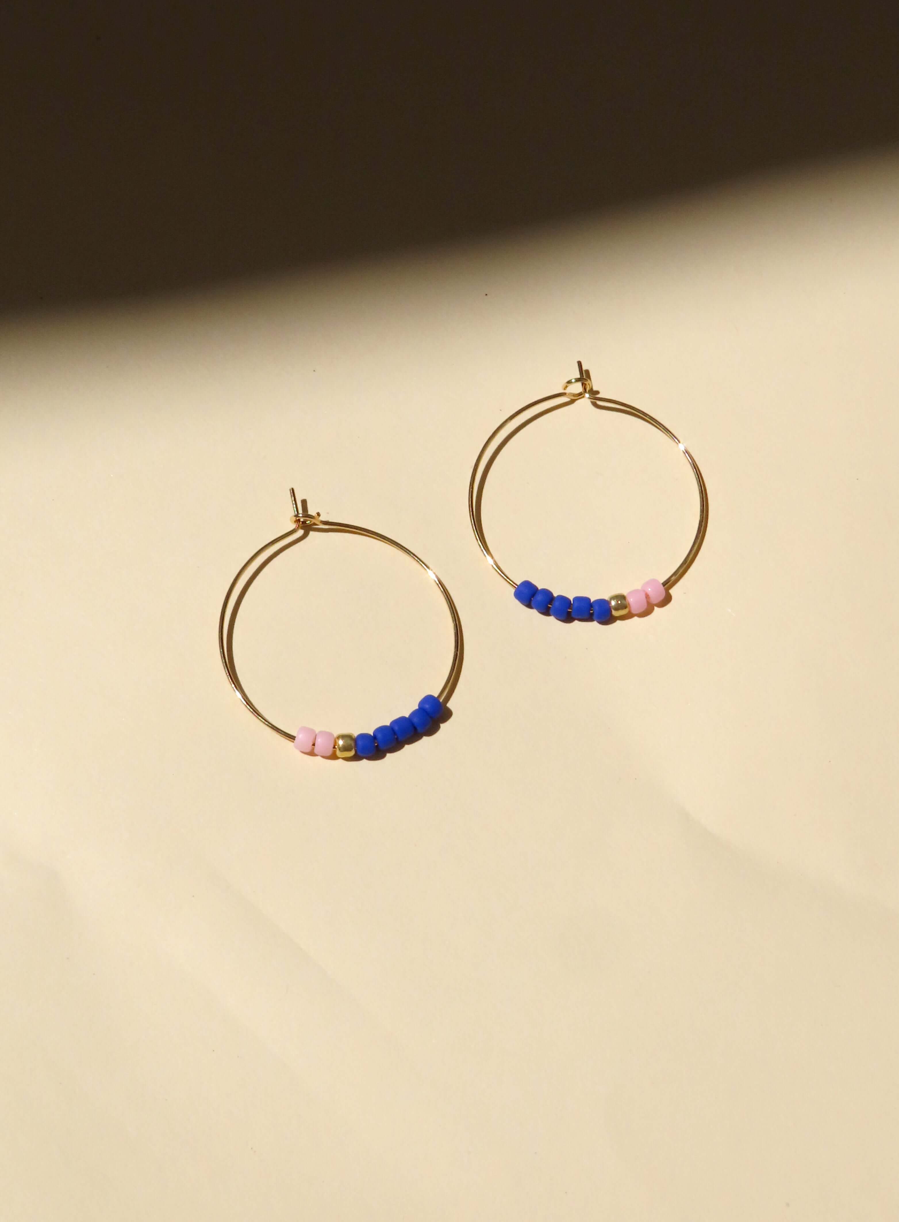 Goldfarbene Edelstahl-Creolen mit rosa und royalblauen Toho Seed Beads sowie goldenen Akzenten