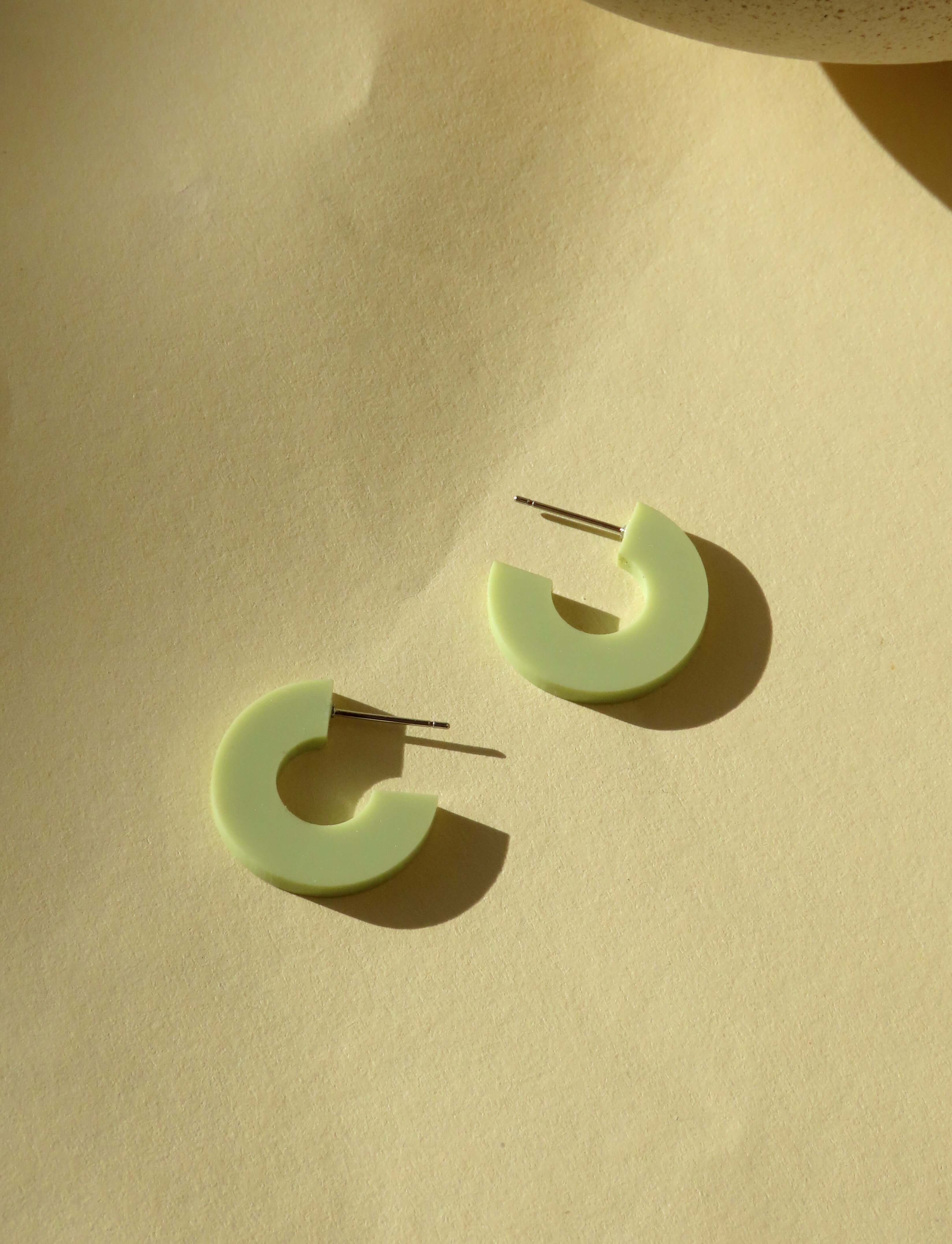 Minimalistische Acryl Creolen in hellem Pastellgrün mit reduzierter Kreisform und Edelstahlstift