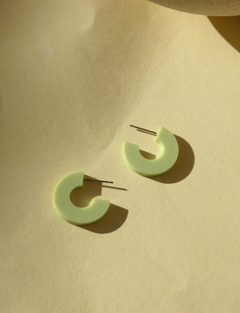 Minimalistische Acryl Creolen in hellem Pastellgrün mit reduzierter Kreisform und Edelstahlstift