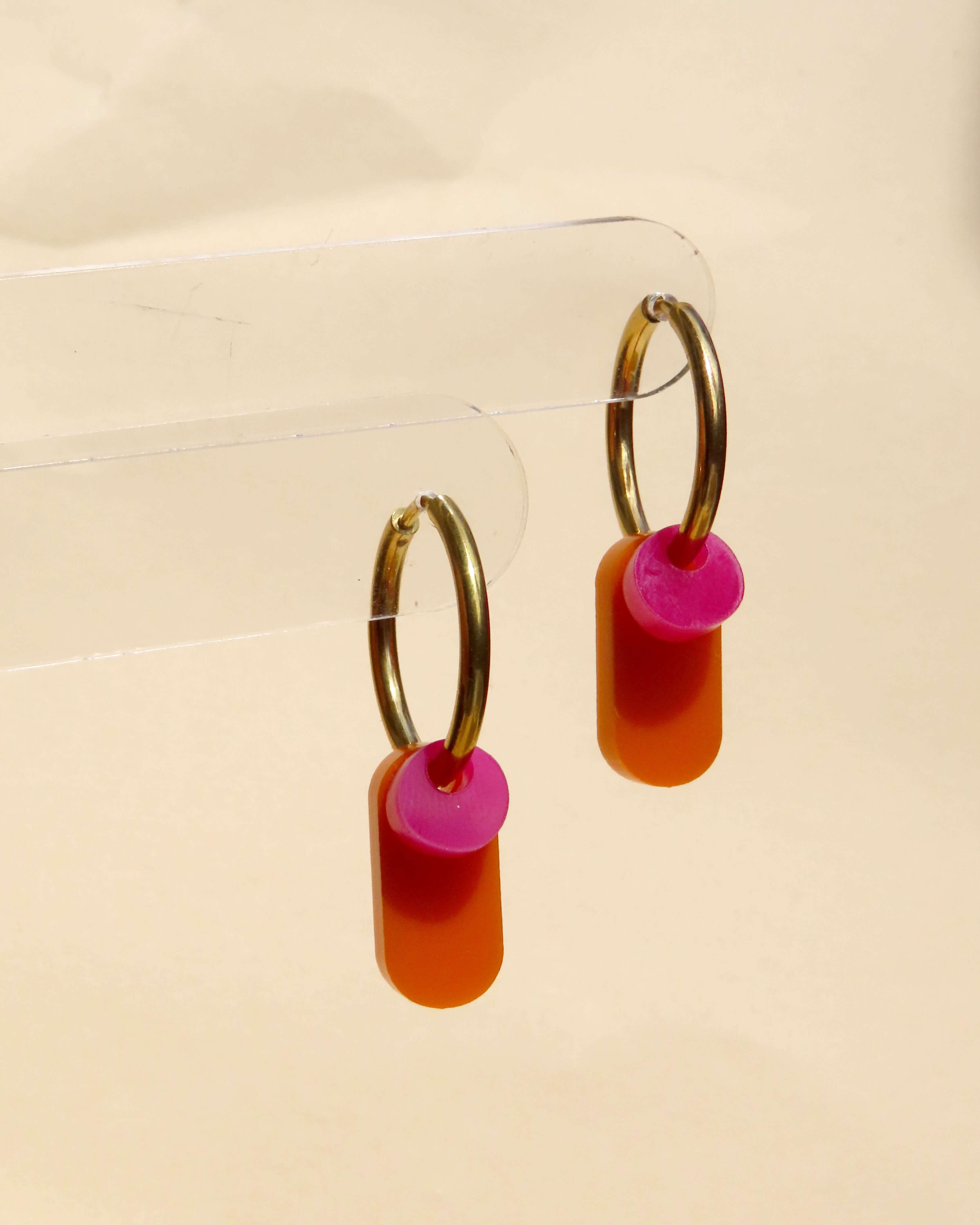 Creolen aus goldfarbenem Edelstahl mit pinken und orangenen Acrylanhängern in länglicher Form