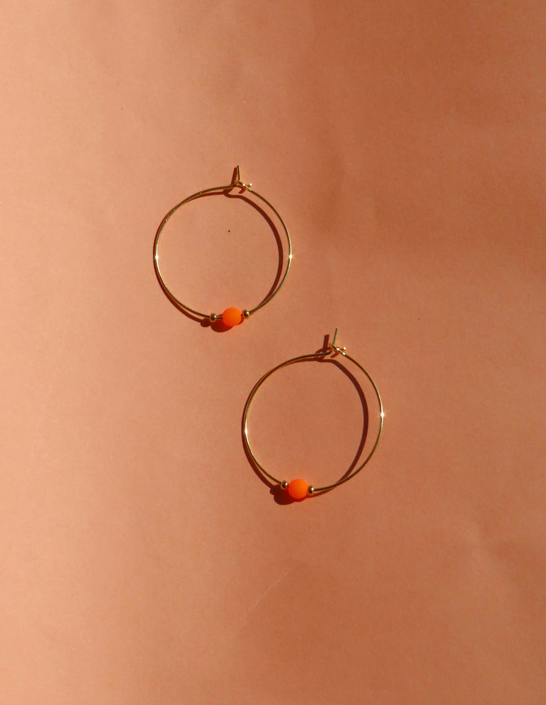 Goldfarbene Edelstahl-Creolen mit Neon-Orange Glasperle und kleinen Goldperlen