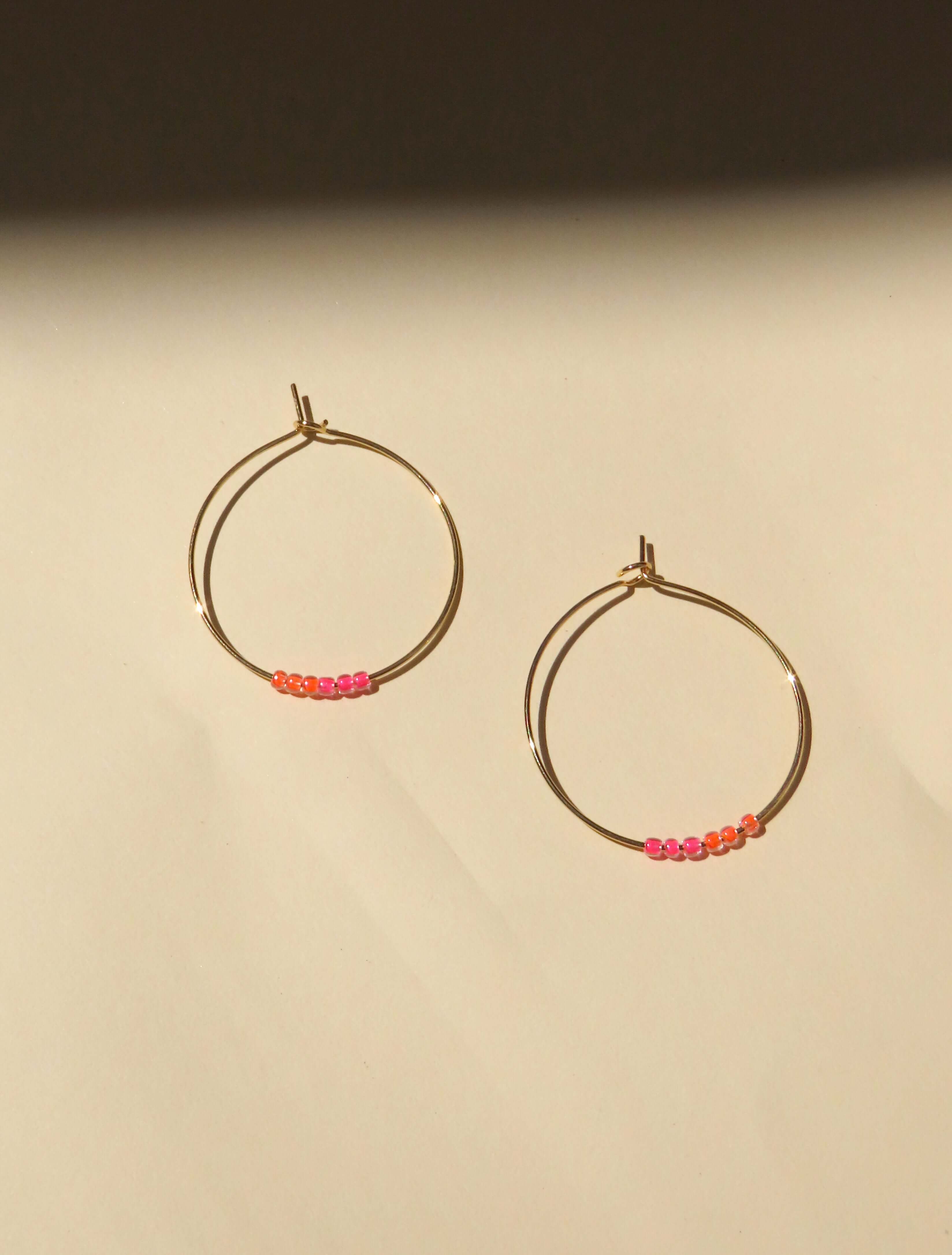 Filigrane Edelstahl-Creolen mit neonpinken und neonorangenen Toho Seed Perlen aus Glas