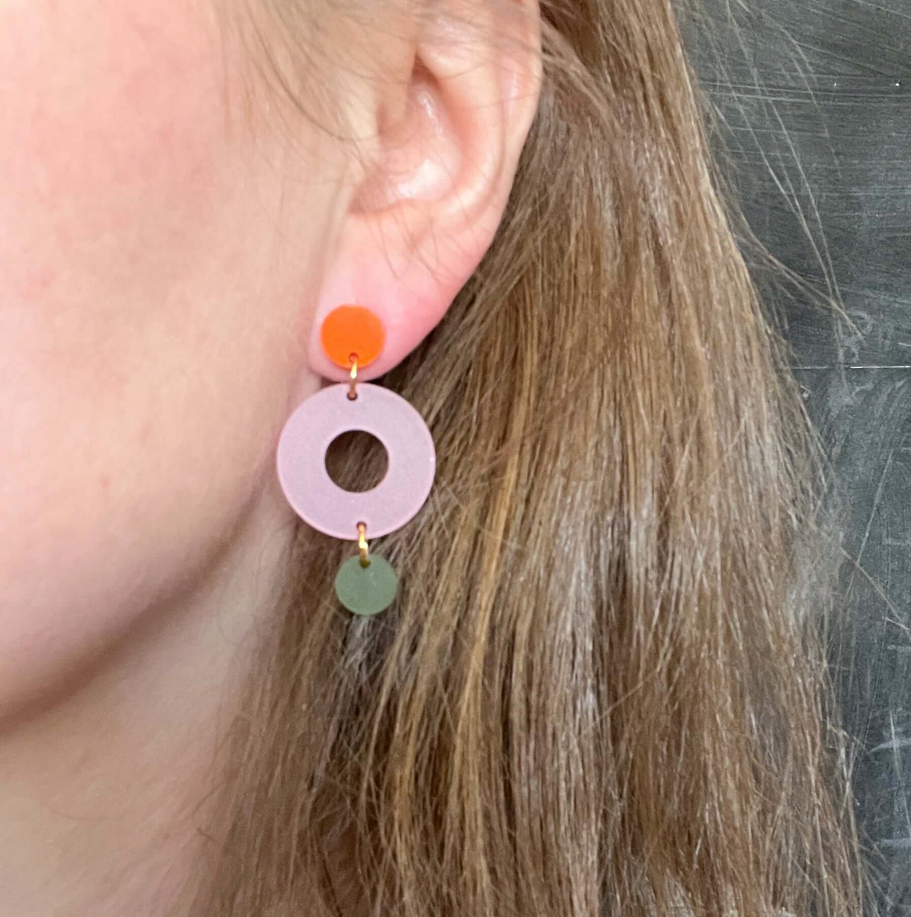 dangle-ohrringe aus acryl mit orange scheibe, rosa ringform und transparent oliv scheibe