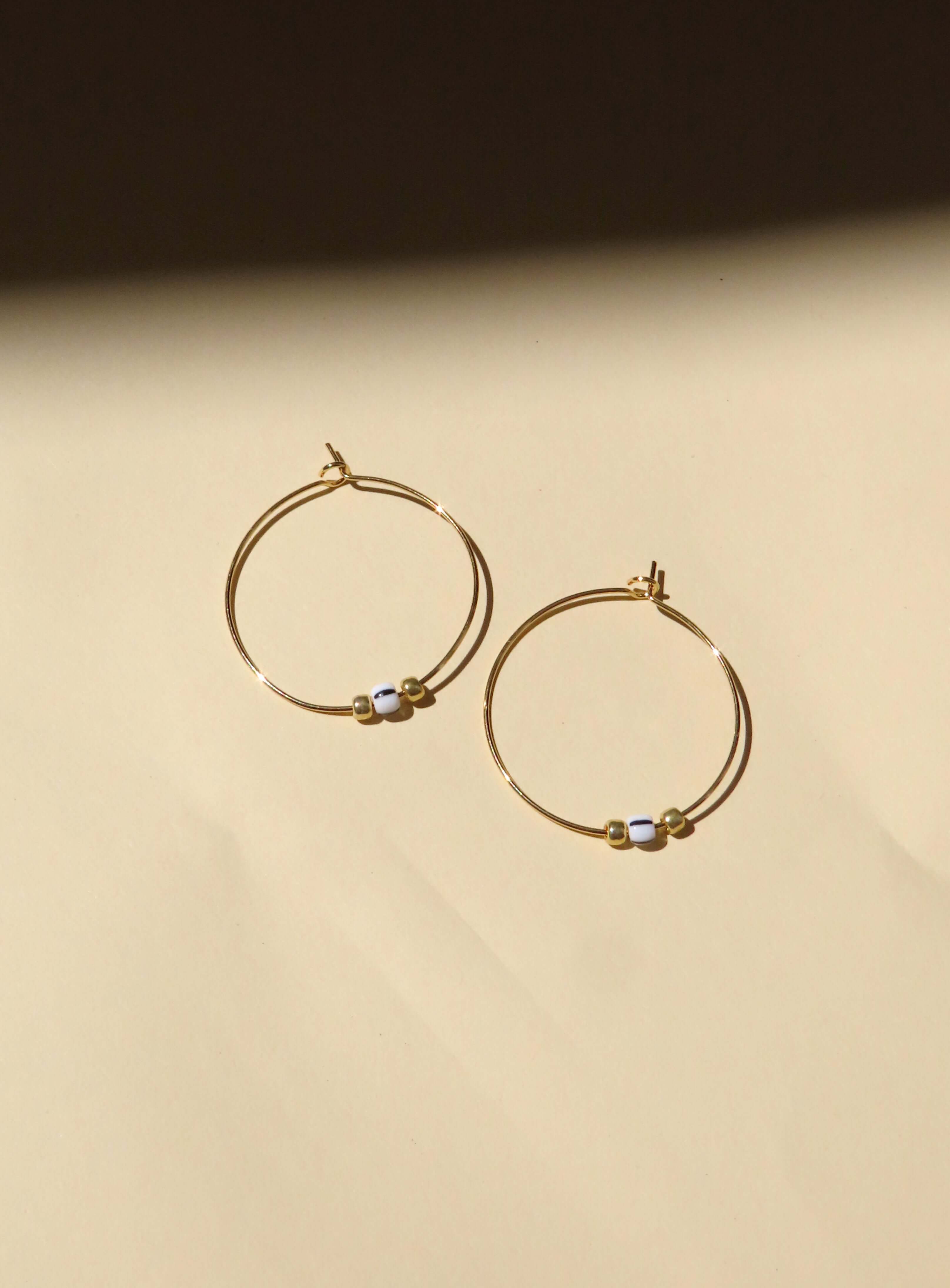 Filigraner vergoldeter Edelstahl Hoop-Ohrring Ø 3 cm mit schwarzochweißen Glasperlen und goldenen Akzenten