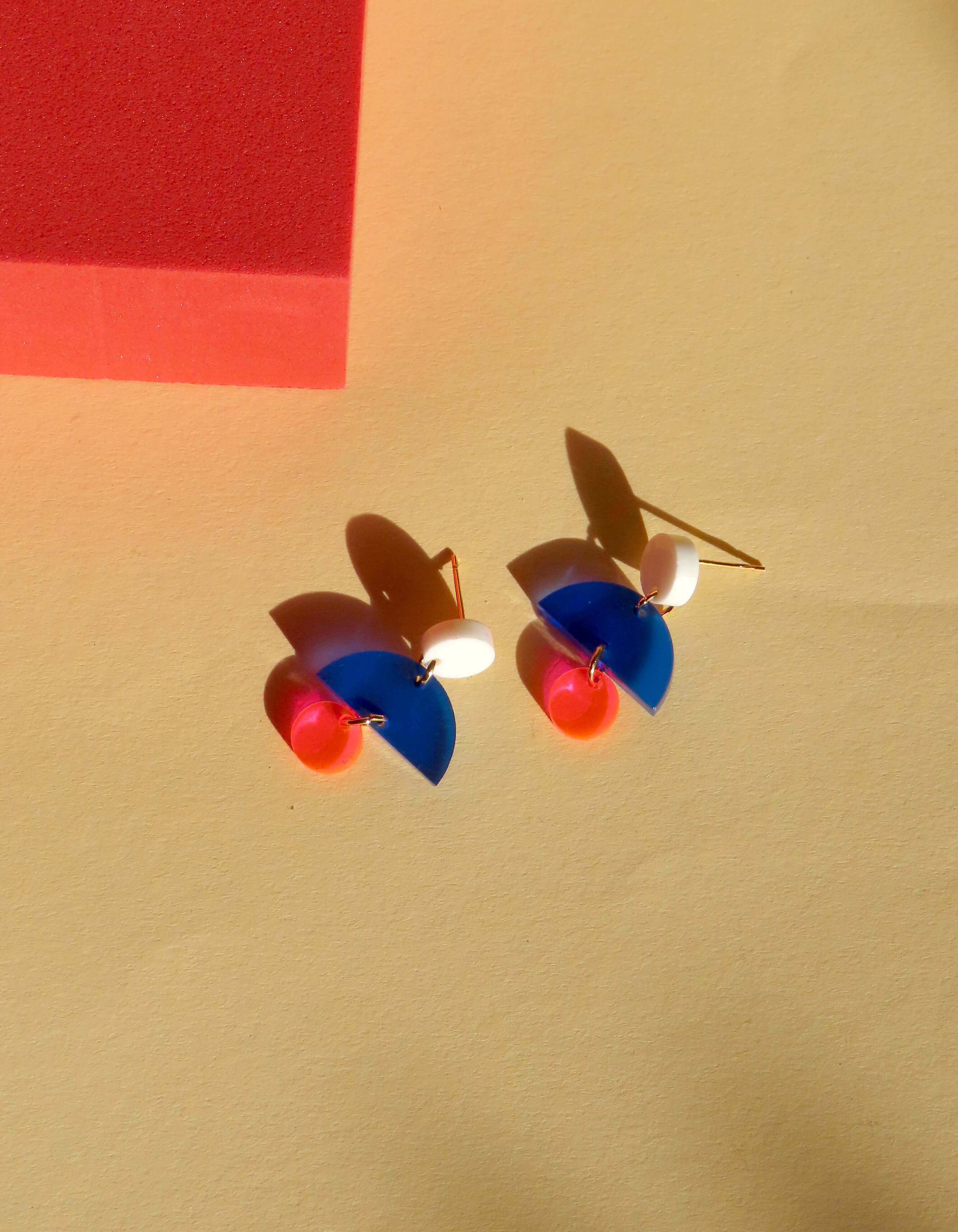 handgefertigte French Ohrringe aus Acryl mit weißem Kreis, blauem Halbkreis und neonpinken Anhängern