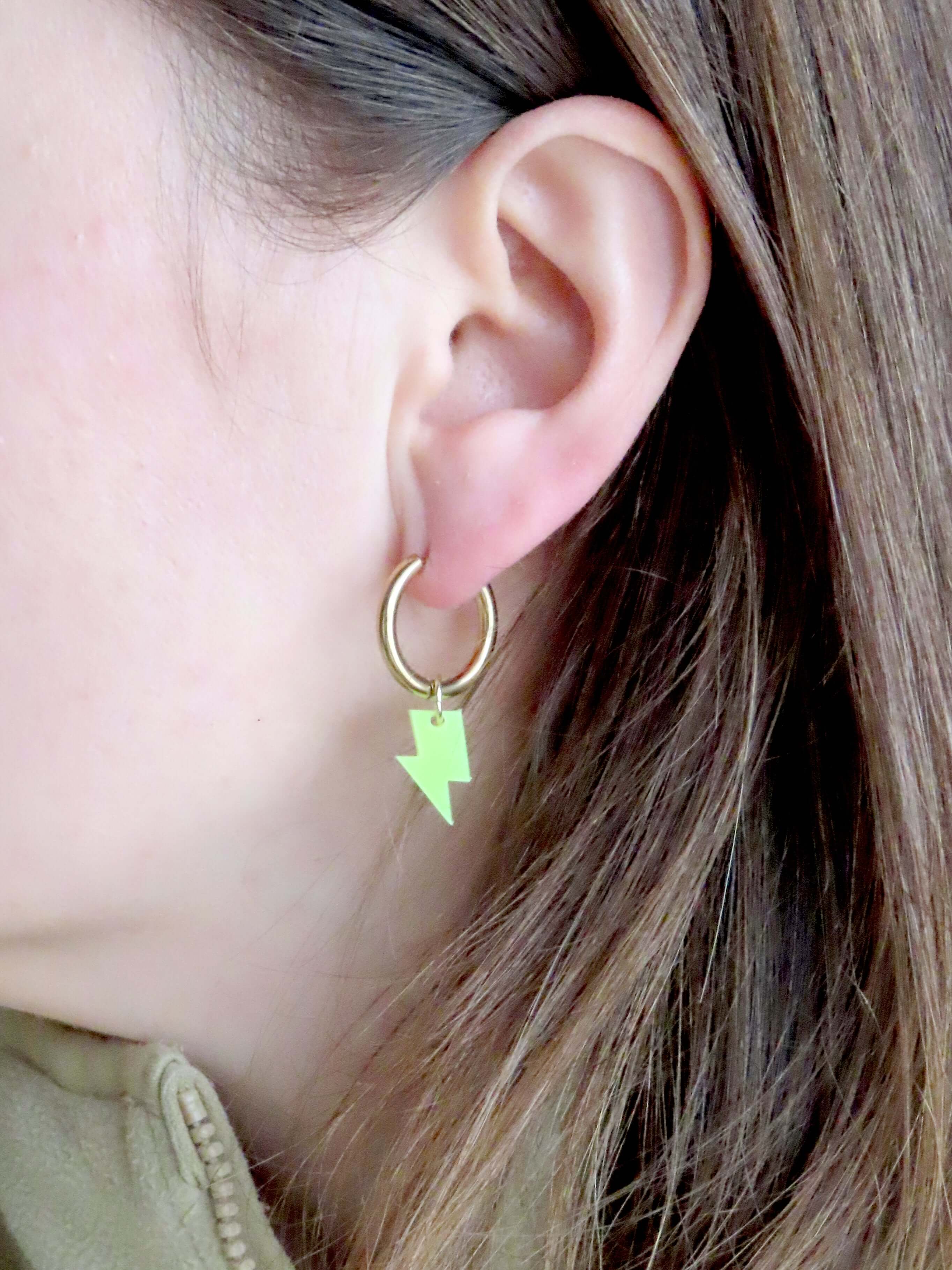minimalistische ohrringe mit kleinen blitzanhängern aus neon­gelbem acryl und goldener creole