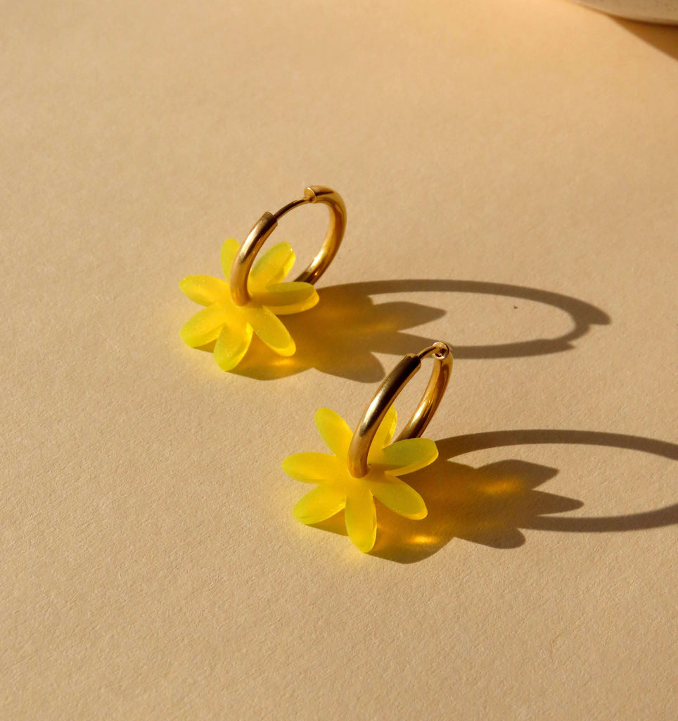 Goldfarbene Edelstahl-Creolen mit gelber Acrylblume in Margaritenform, transparent schimmernd