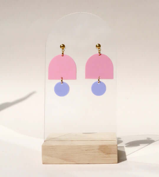 Statement-Ohrringe aus Acryl in Pastellfarben, oben pinker Halbkreis, unten lila Kreis.