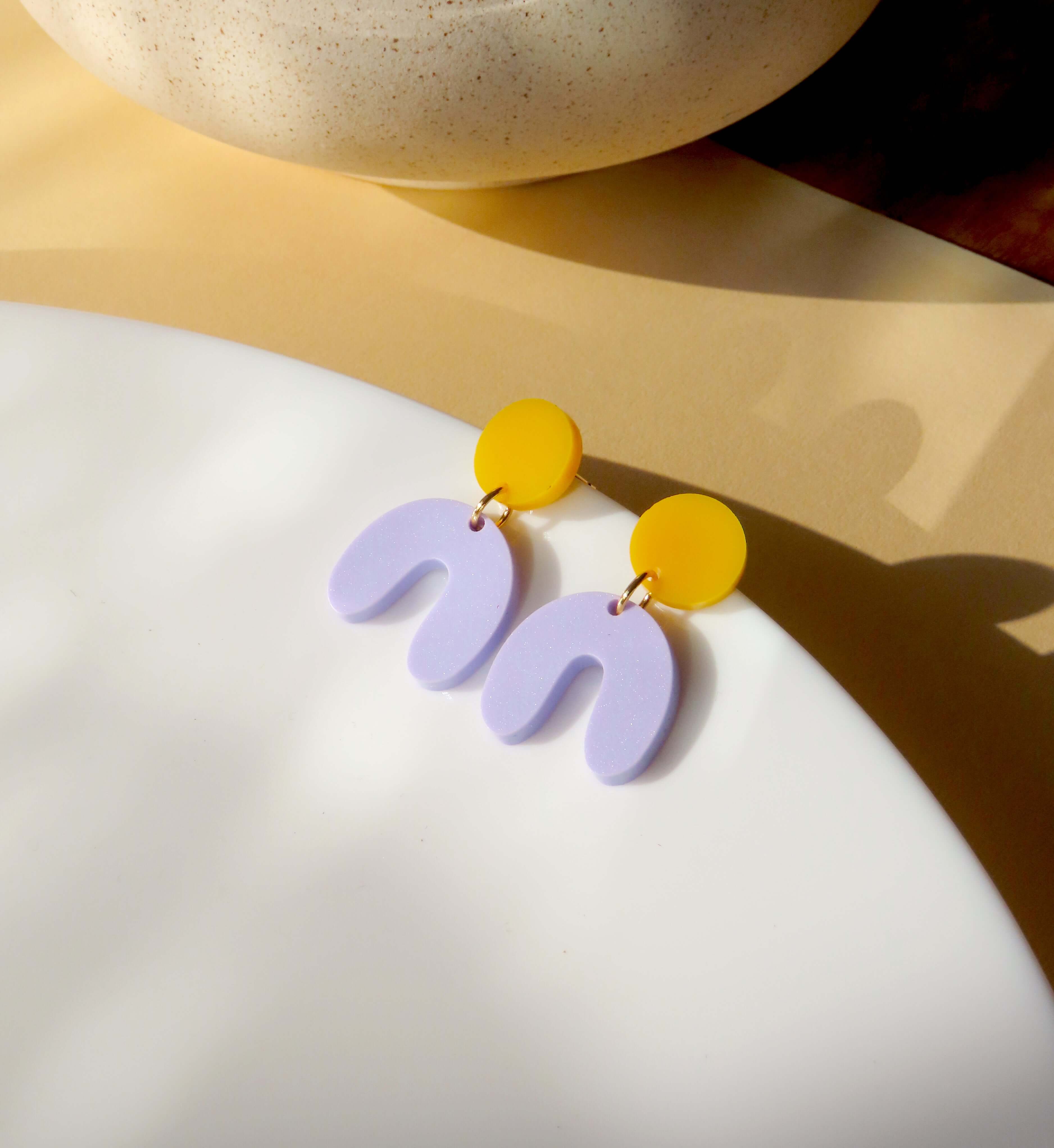 Ohrringe aus Acryl mit rundem goldgelbem Stecker und fliederfarbenem Bogenanhänger in U-Form, Größe 3 x 2 cm