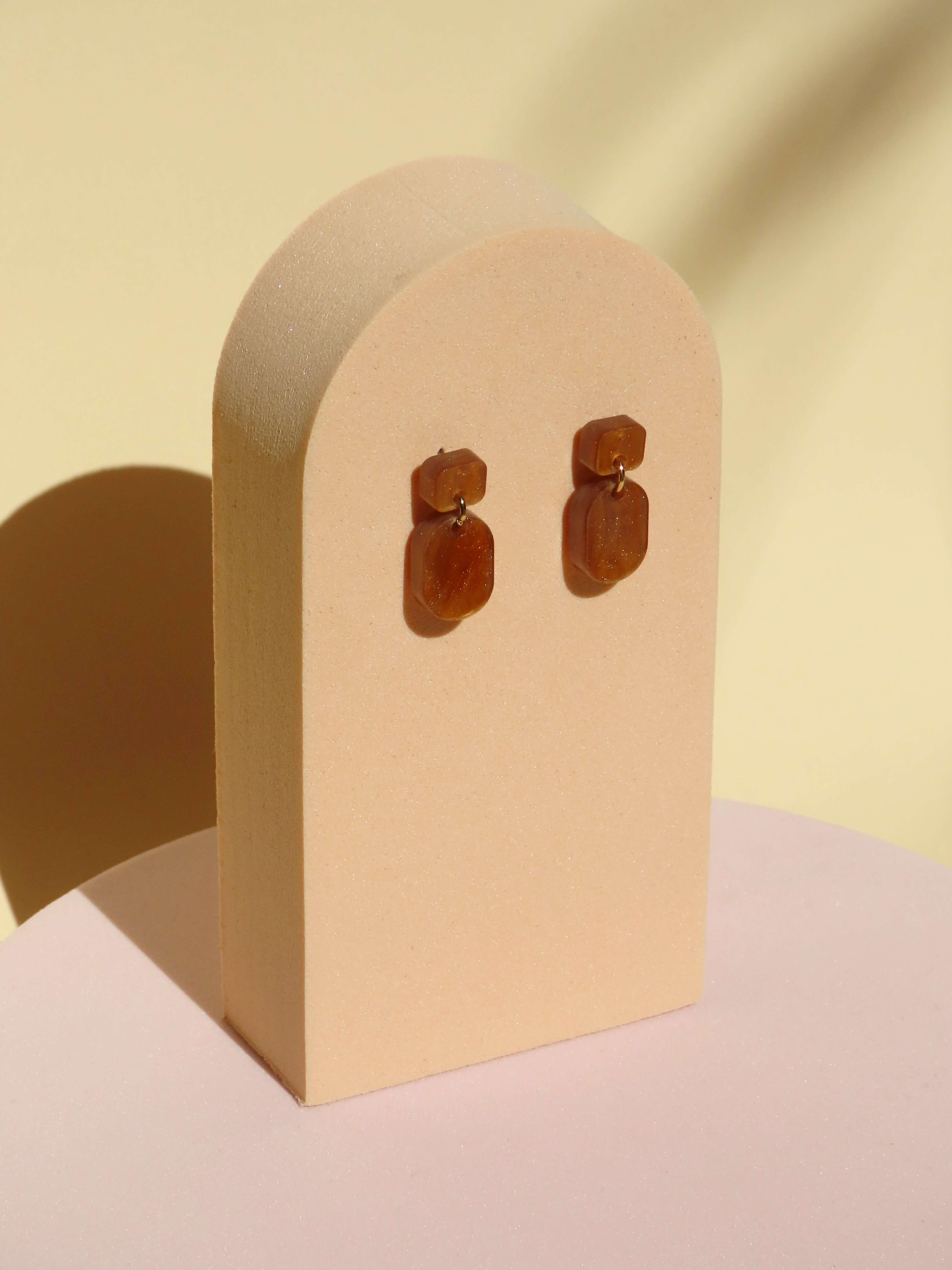 Kleine braune Acryl Ohrhänger in Karamelloptik mit sanftem Glanz, eckiger Stecker, ovaler Anhänger, Edelstahlstecker