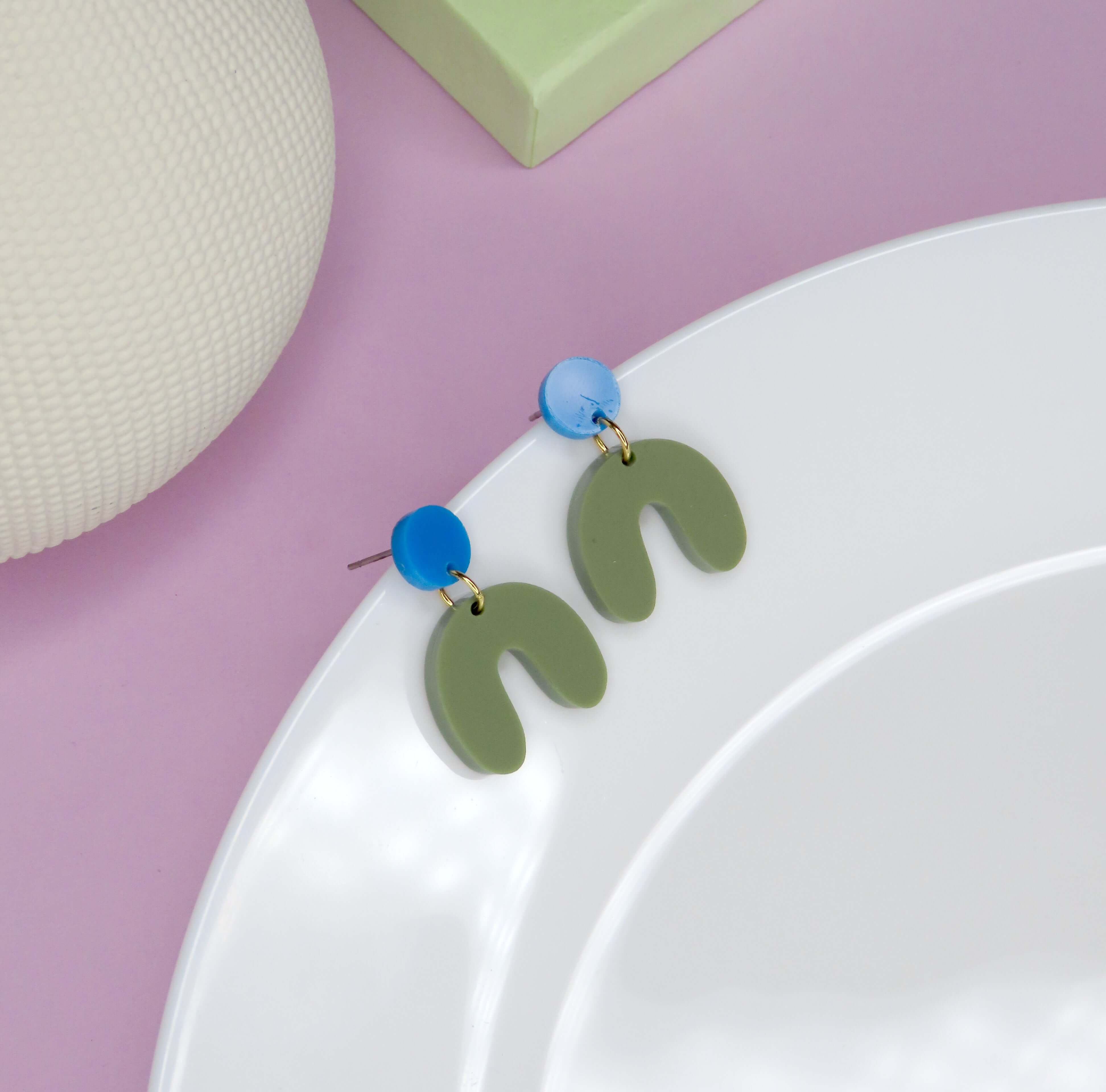 Handgefertigte Ohrringe mit blauem Kreisstecker und geschwungenem, olivgrünem Acrylbogen, Länge 3 cm, Breite 2 cm