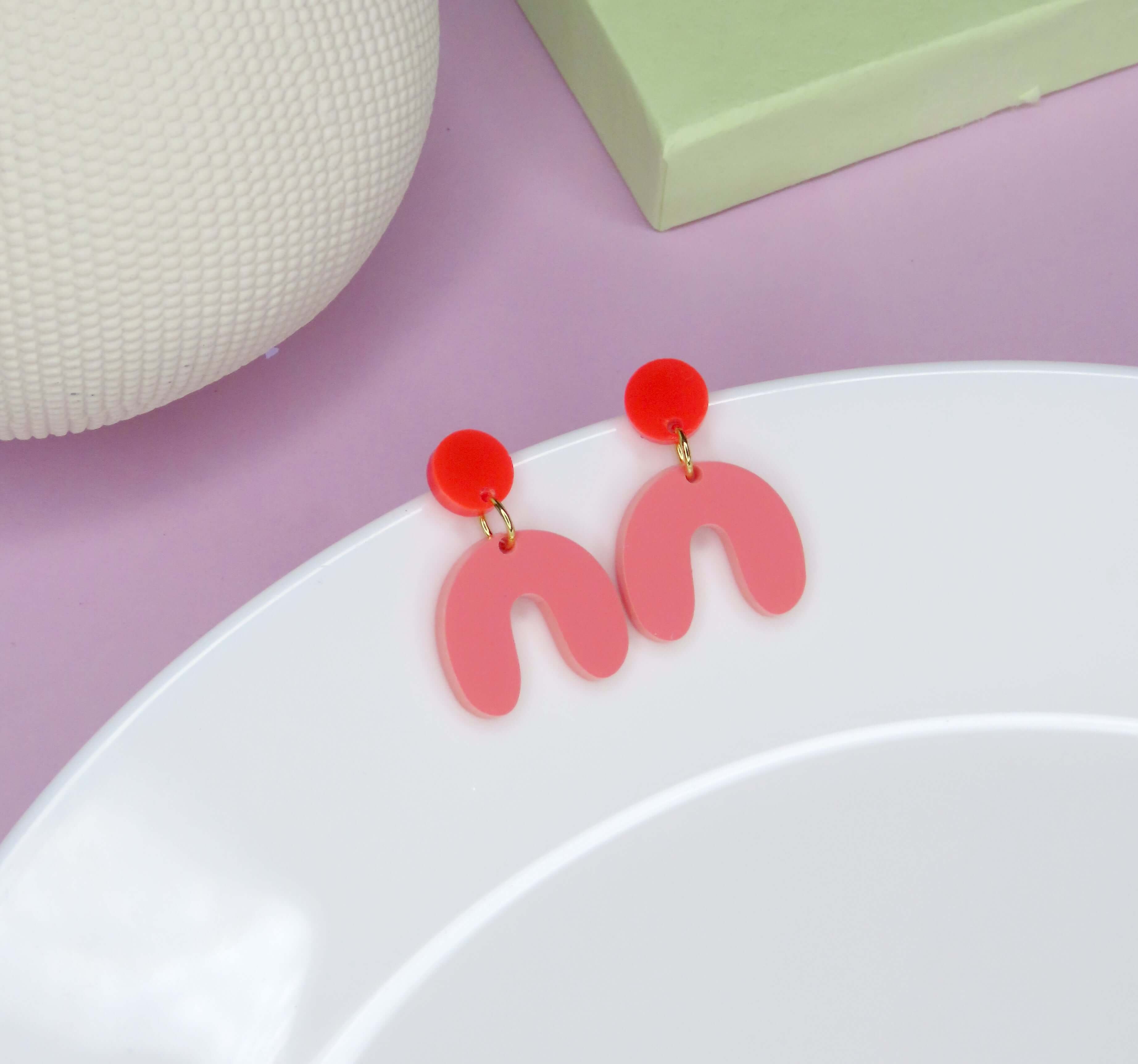 Statement-Ohrringe mit rundem roten Stecker und geschwungenem Anhänger in Rosa aus Acryl