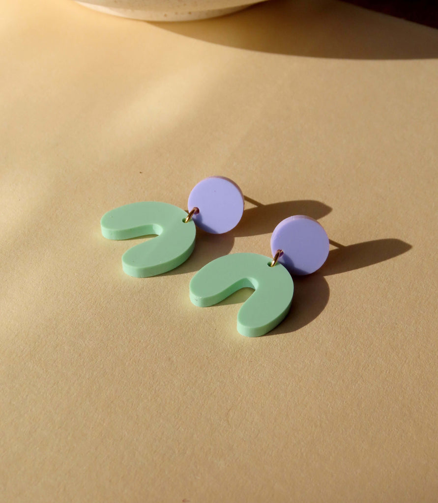 Zweifarbige Ohrringe mit rundem Fliederstecker und geschwungenem mintgrünen Anhänger aus Acryl