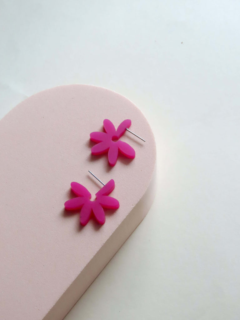 Runde Flower Creolen aus Acryl in Pink-Violett mit dynamisch angeordneten Blütenblättern und zarter Edelstahlfassung