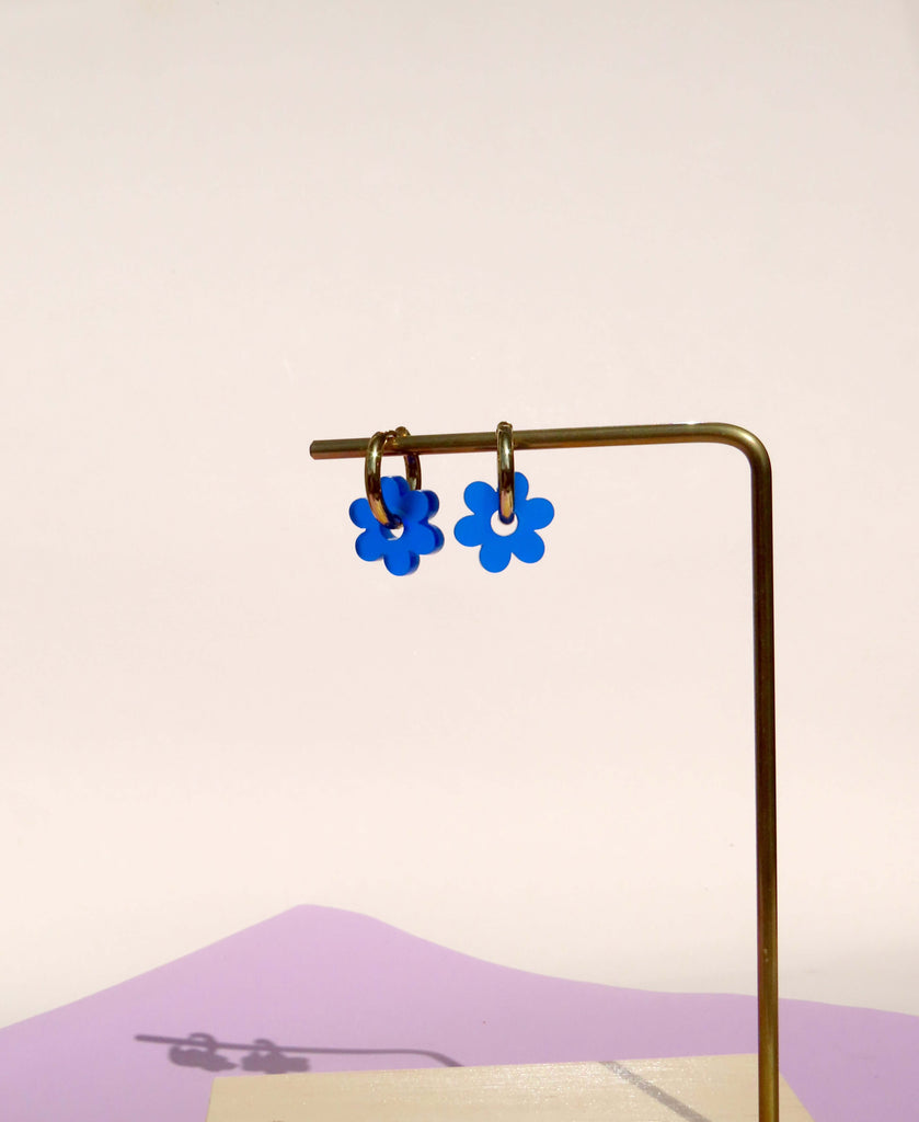Verspielte Ohrringe mit blauer Blume aus Acryl und minimalistischer Creole