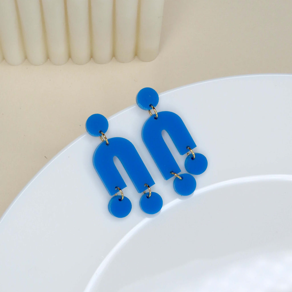 Asymmetrische Mismatch Ohrringe aus Acryl in kräftigem Azurblau mit Bögen und Kreisen, Edelstahlstecker